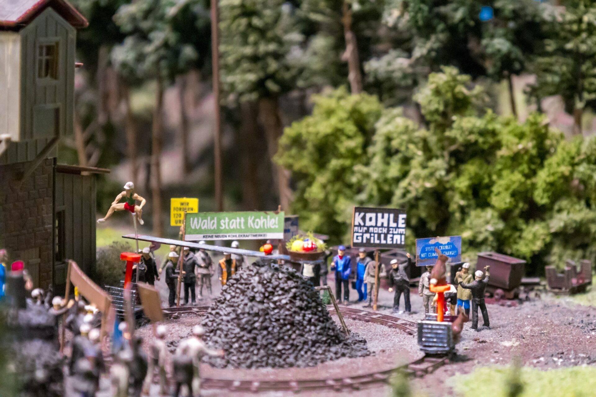 Diorama in miniatura di una miniera tedesca con manifestanti, cartelli di protesta e cumuli di carbone