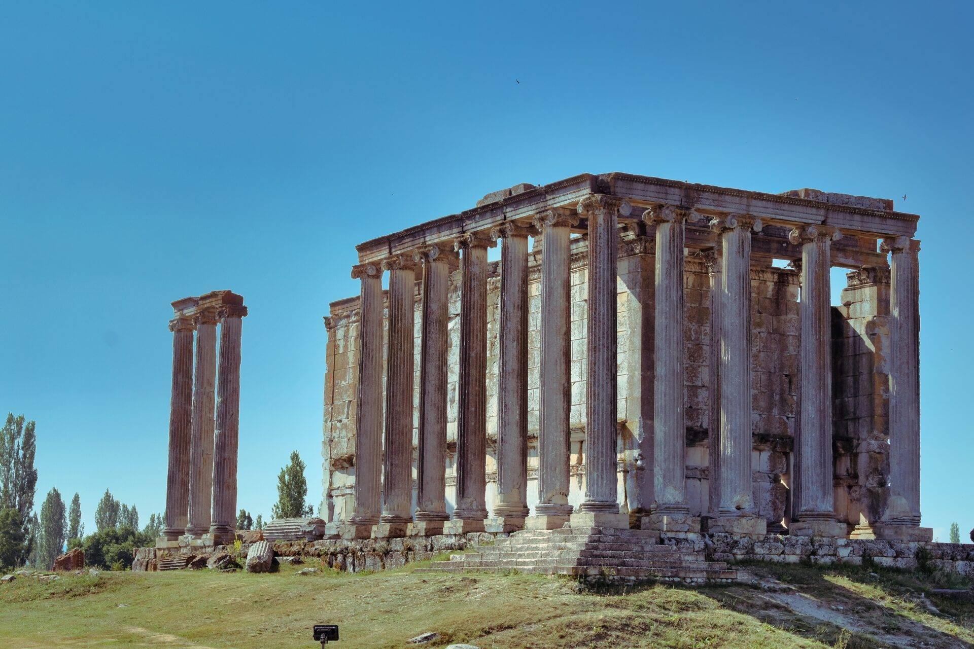Rovine di un tempio antico con imponenti colonne corinzie sotto un cielo blu sereno