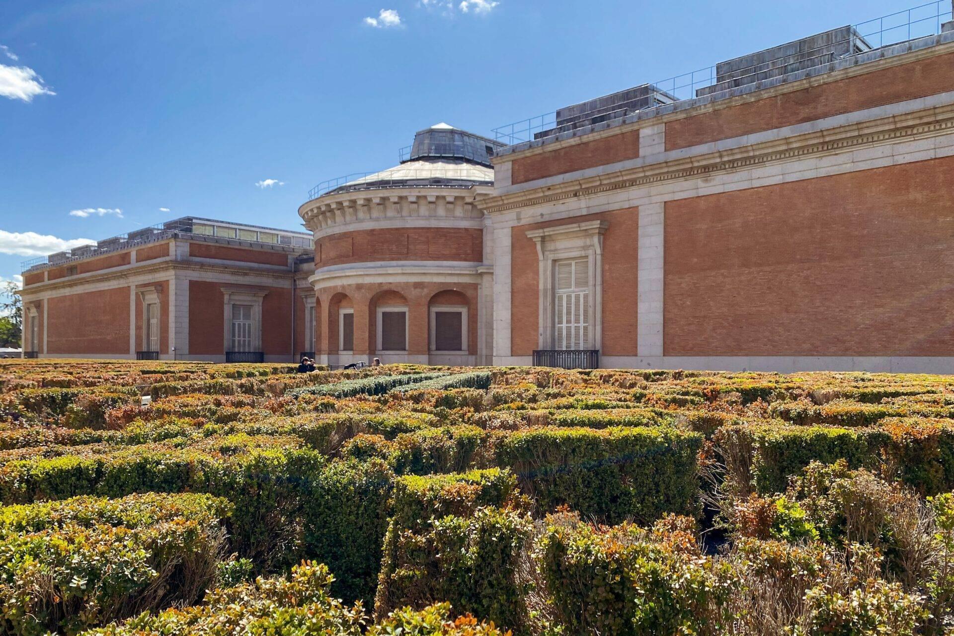 Museo in mattoni rossi con cupola vetrata circondato da giardini fioriti gialli a terrazze