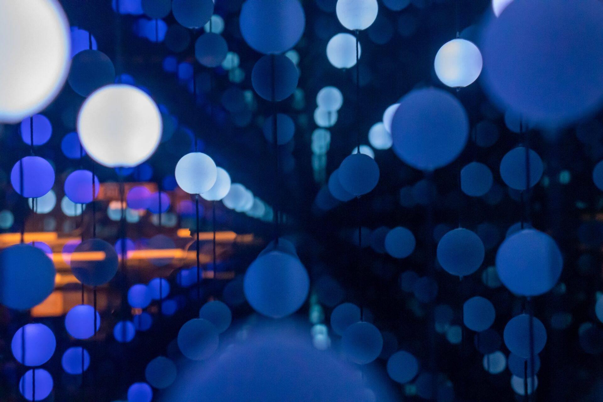 Nächtliche Straßendekoration mit blauen und weißen Lichterketten, die eine festliche urbane Atmosphäre schaffen