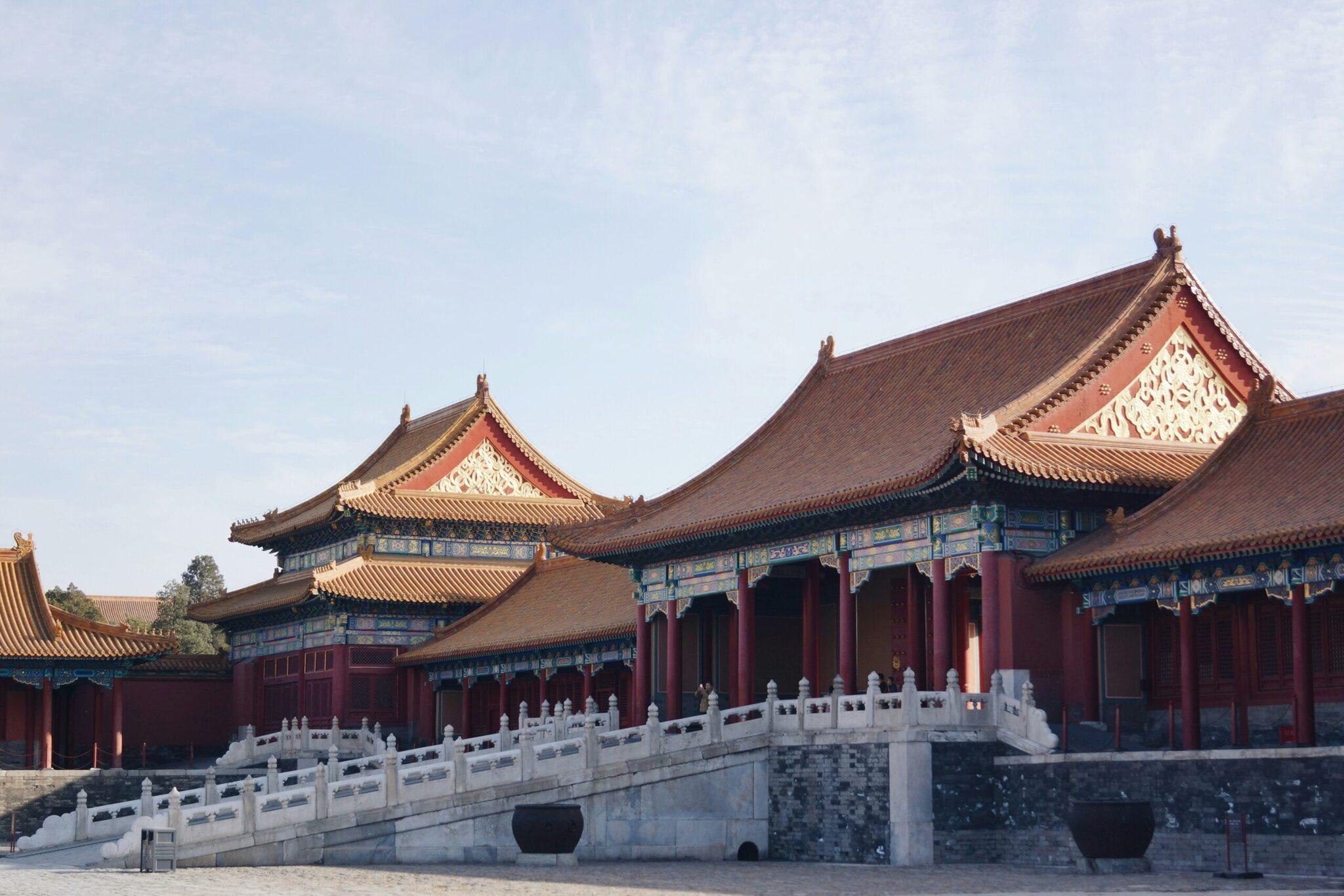 Arquitectura tradicional china con tejados dorados, edificios rojos y balaustrada de mármol blanco