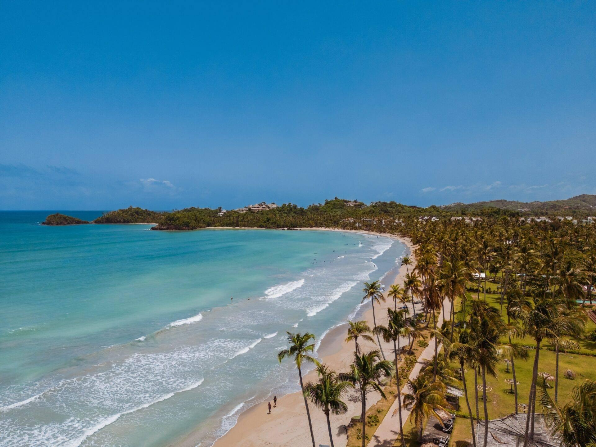 Weißer Sandstrand auf der Dominikanischen Republik mit Palmen und türkisblauem Meer
