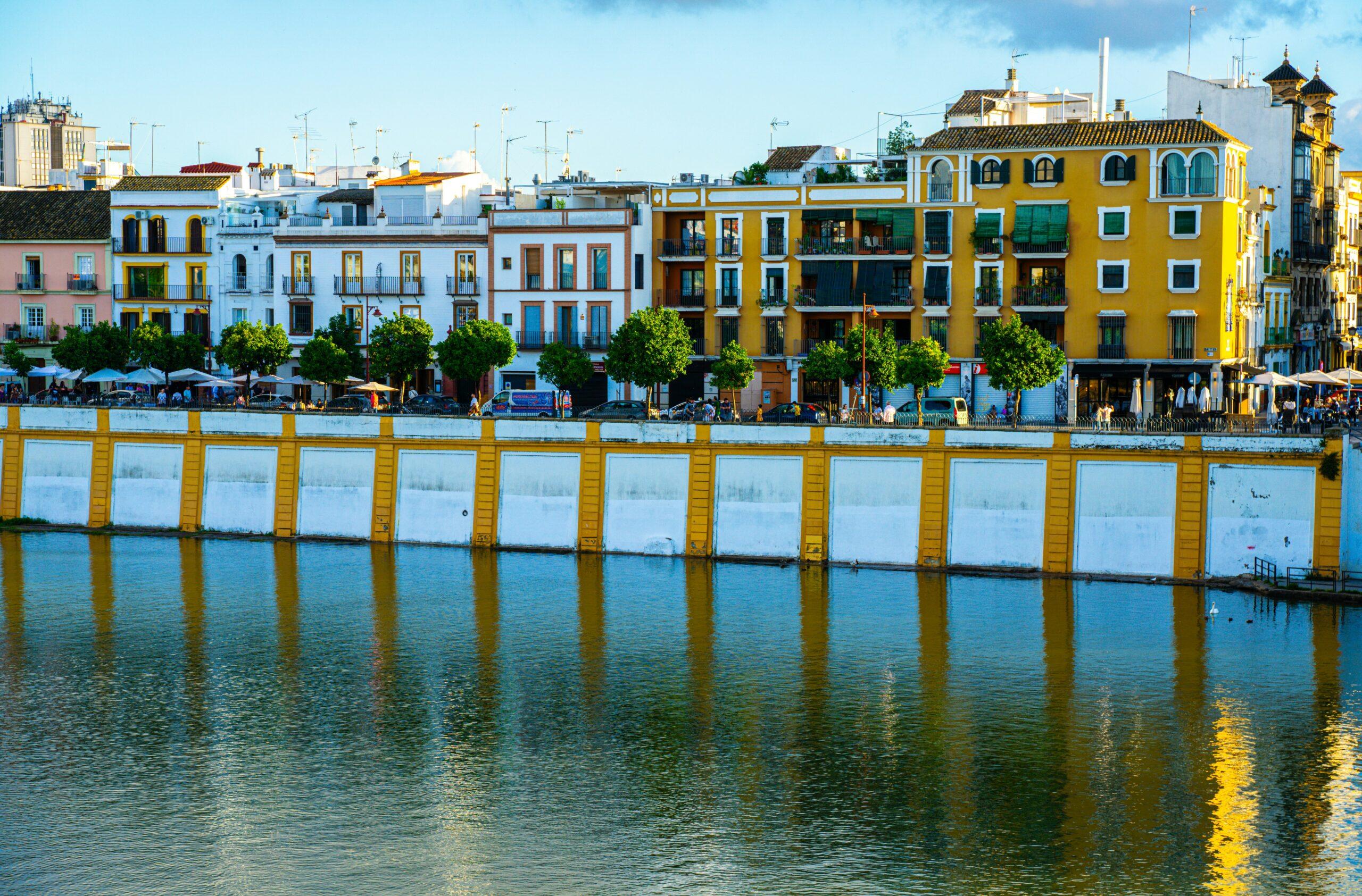 Fachadas de colores de edificios históricos sobre el río con estructuras portuarias amarillas