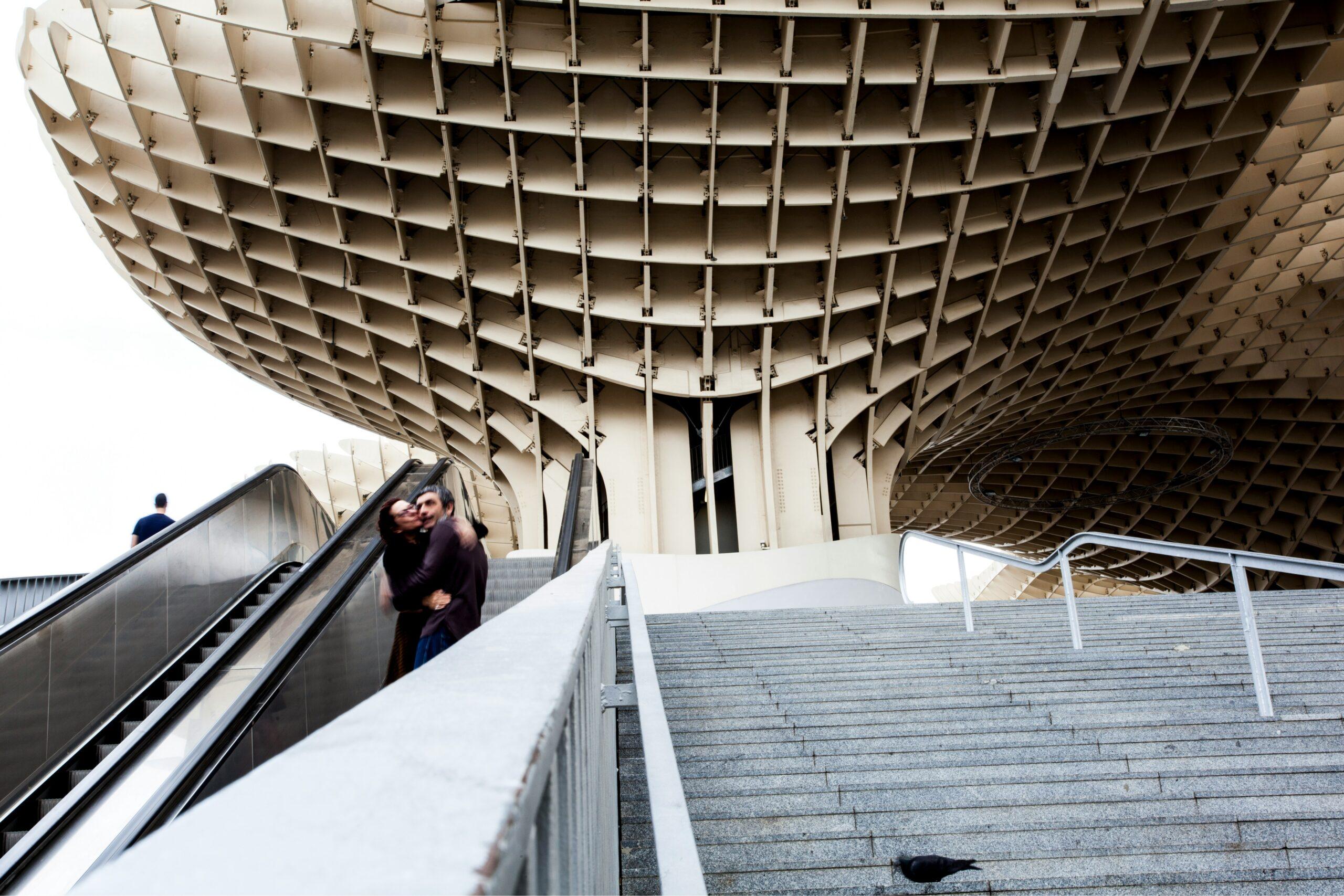 Escaleras modernas y escalera mecánica que llevan a un edificio contemporáneo de estructuras geométricas blancas