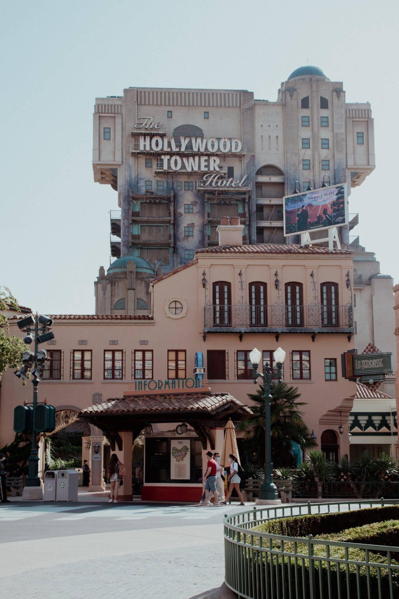 Das Hollywood Tower Hotel mit seiner rosa Art-déco-Architektur, Türmen und dem ikonischen Schriftzug in einem Themenpark