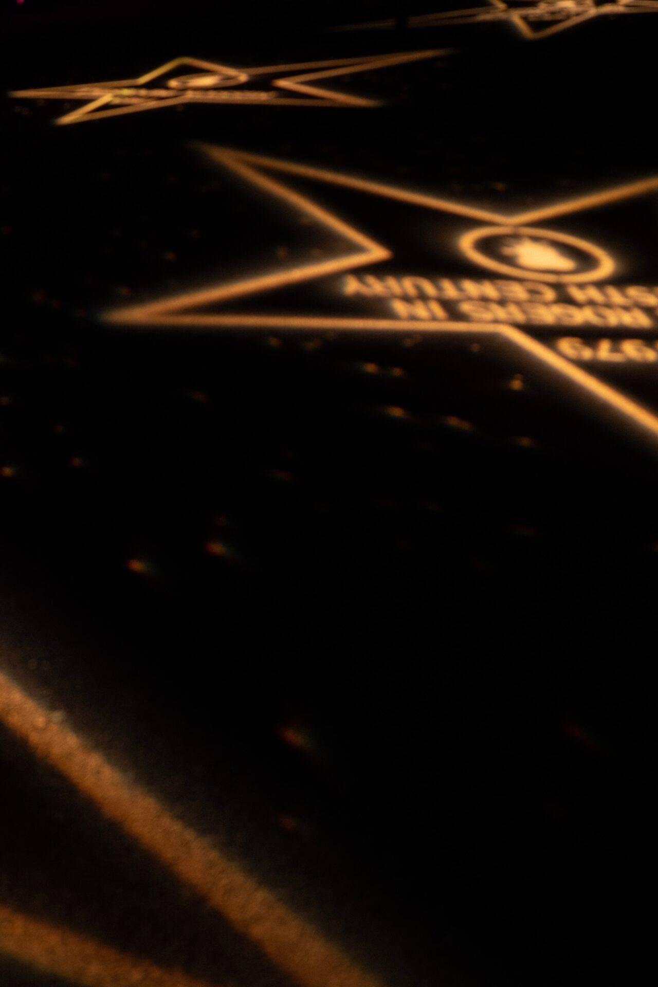 Froschperspektive auf eine nachts beleuchtete goldene Architektur mit geometrischen Linien und Zierelementen