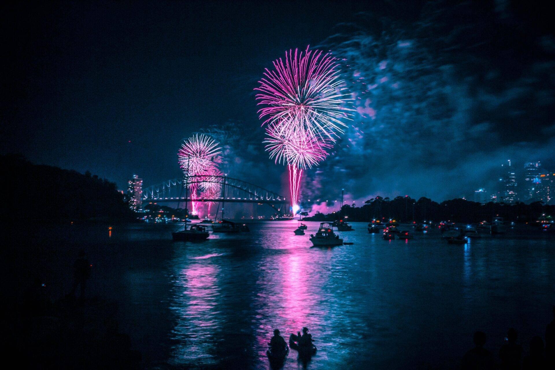 Fuochi d’artificio che esplodono sopra il porto di Sydney con l’Opera House e l’Harbour Bridge nella notte di Capodanno
