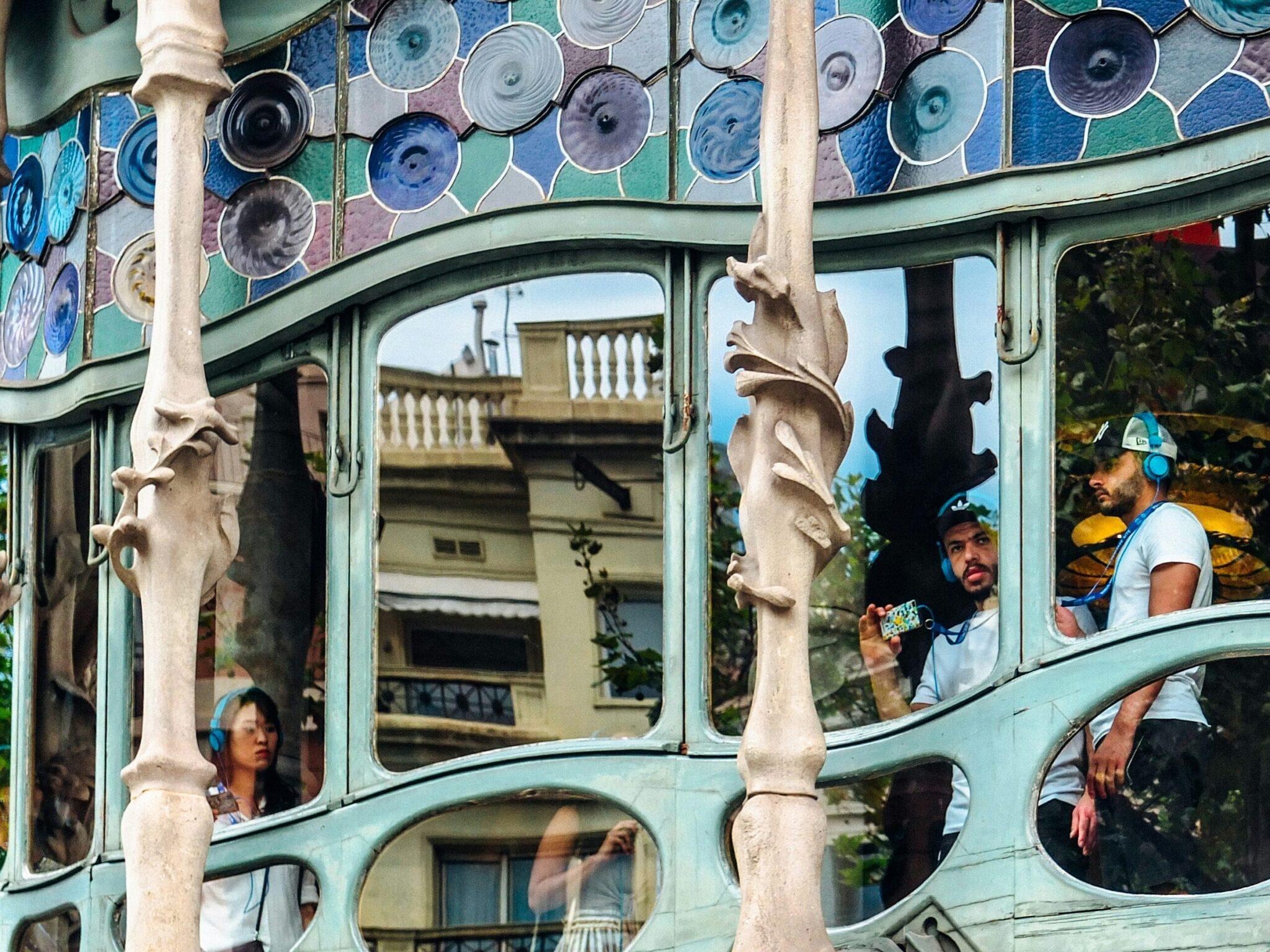 Fachada colorida con placas decorativas y balcones en forma de máscara de un edificio histórico de Barcelona