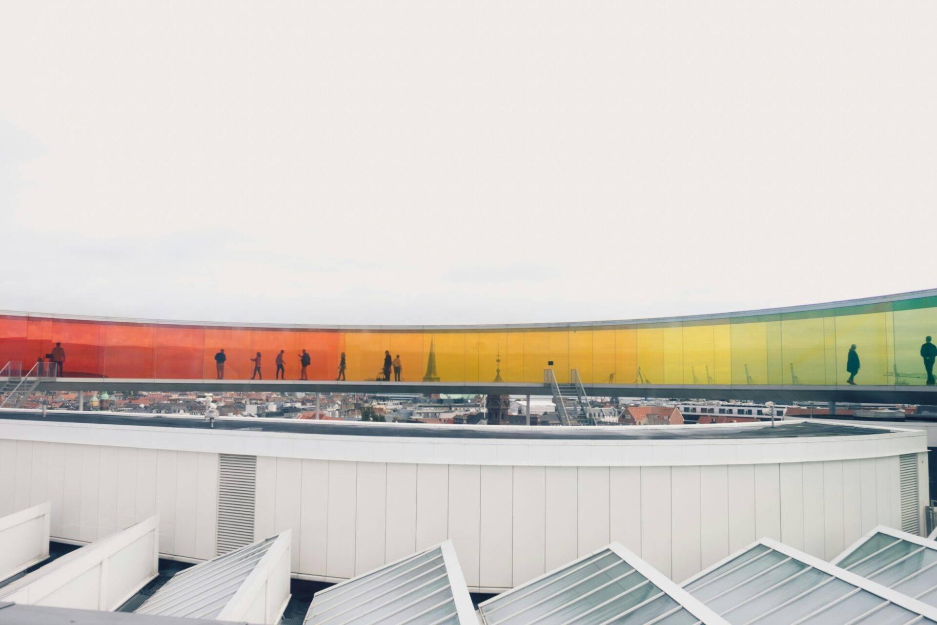 Una terrazza panoramica offre una vista sulla città con un edificio moderno dalle facciate colorate ad arcobaleno