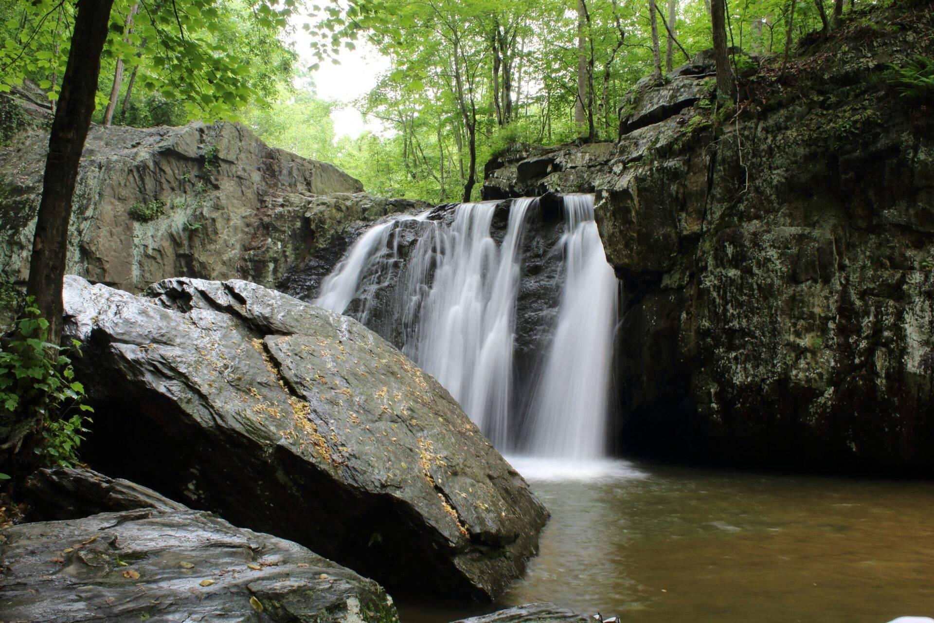 Waterfall and crystal-clear natural pool deep in the jungle at Damajagua