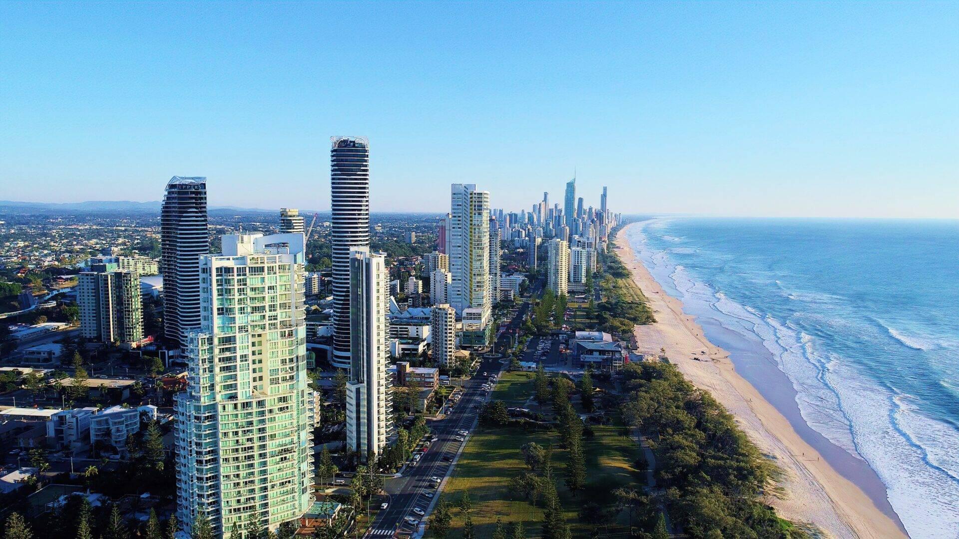 Vista aerea di una località balneare costiera con grattacieli, spiaggia di sabbia e oceano blu