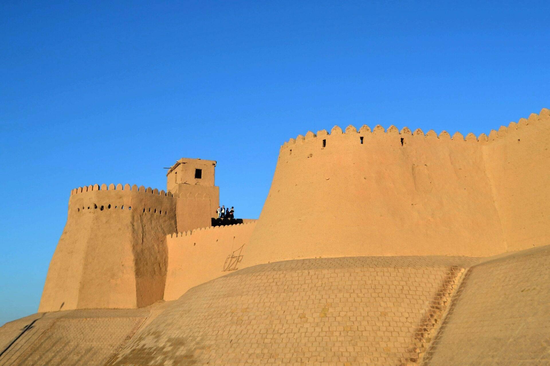 Historische Lehmfestung mit zinnenbewehrten Mauern unter klarem blauem Himmel