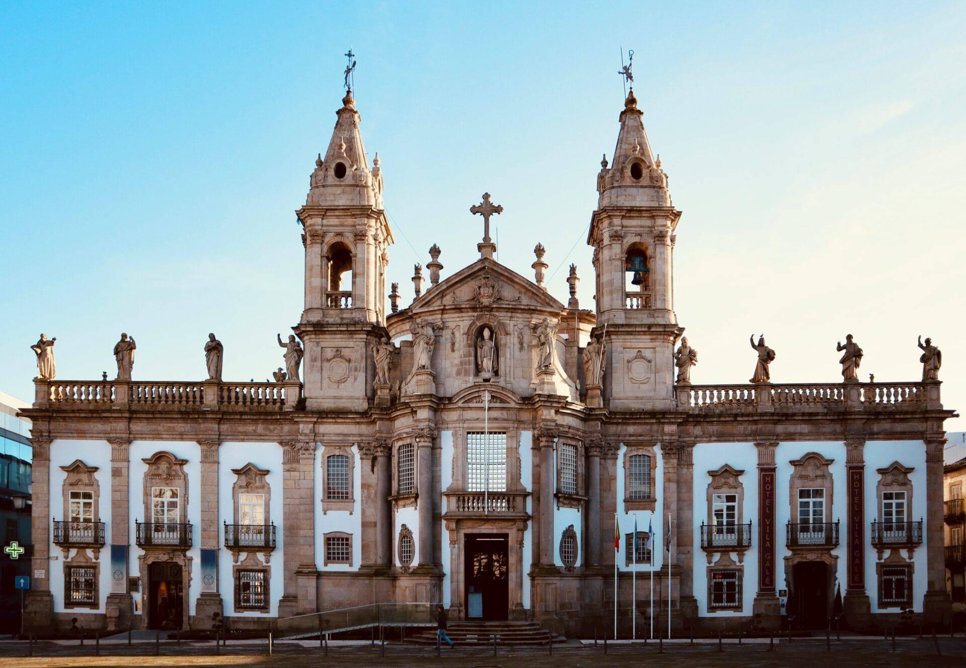 Weiß-goldene Fassade einer barocken Kolonialkirche mit zwei Zwillingstürmen und religiösen Statuen