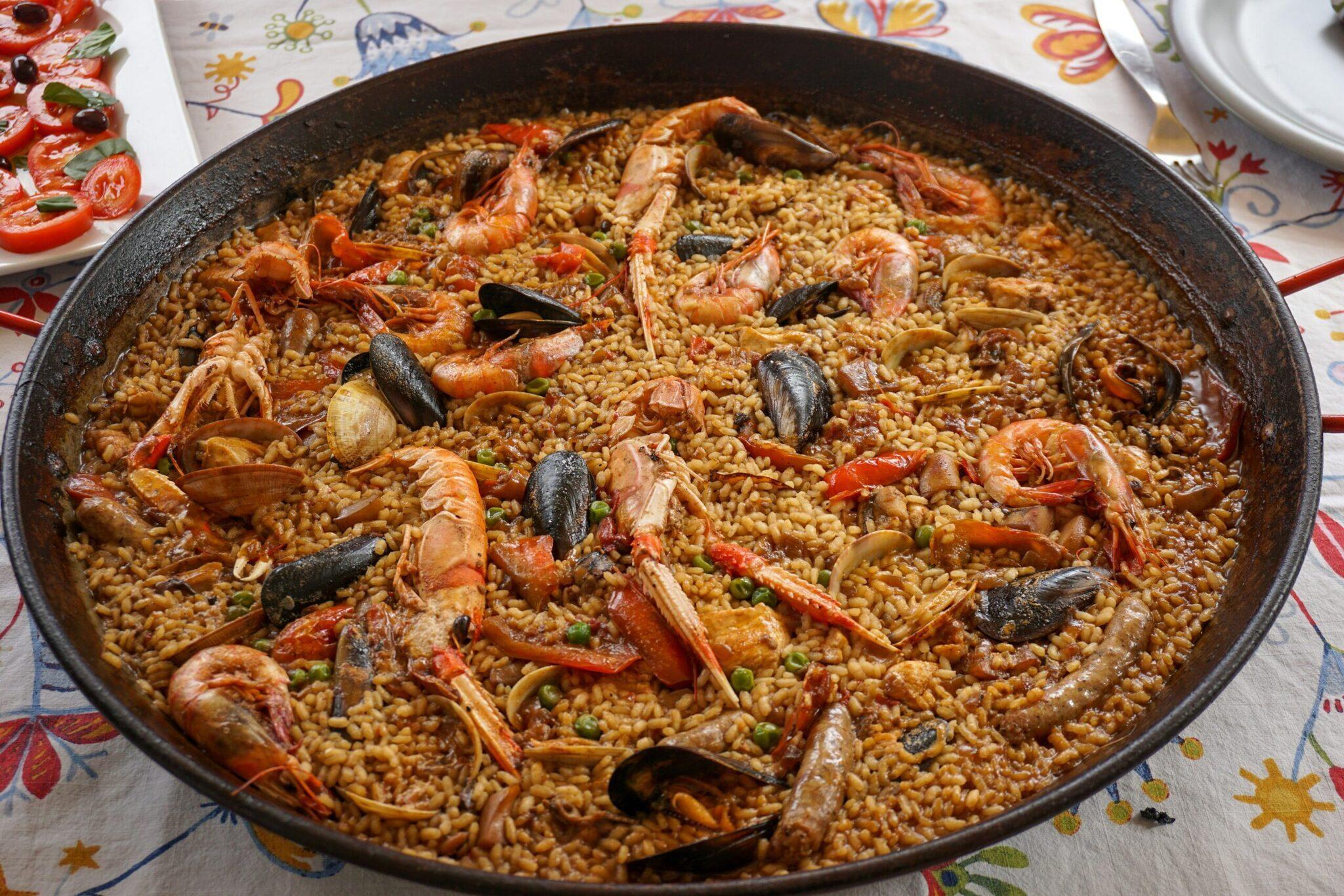 Una paella de marisco con gambas, mejillones y guisantes en una cazuela tradicional de hierro