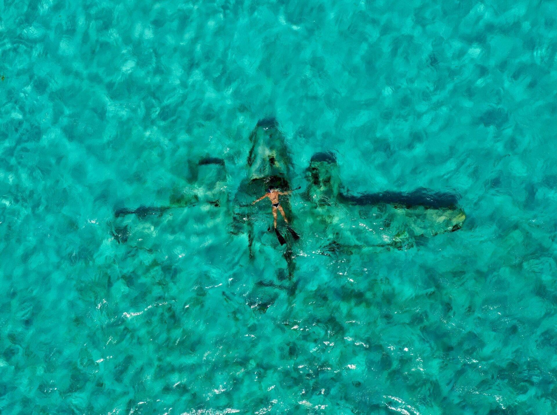 Aerial view of a shipwreck submerged in the crystal-clear turquoise waters of the Bahamas