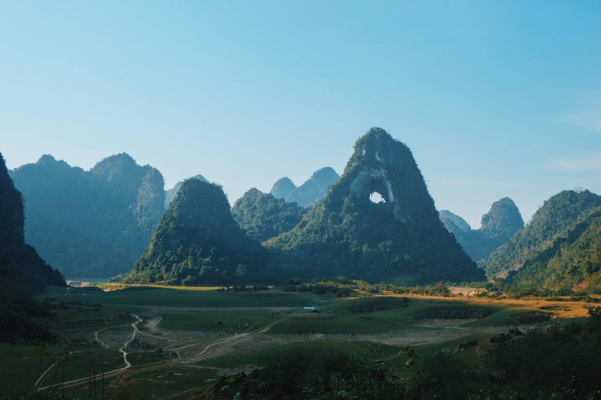 Valle kárstico verde con picos rocosos espectaculares y un río serpenteante en Vietnam