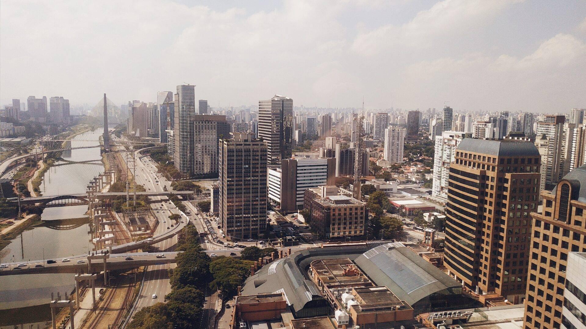 Luftaufnahme einer brasilianischen Großstadt mit Wolkenkratzern, Fluss, Brücken und dichter Stadtarchitektur unter bewölktem Himmel