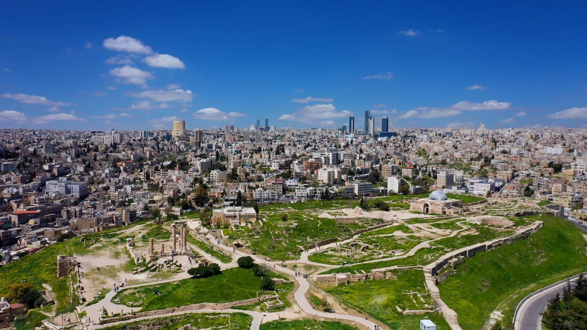Vista aérea de una ciudadela antigua con columnas en el corazón de una ciudad densamente construida bajo un cielo despejado