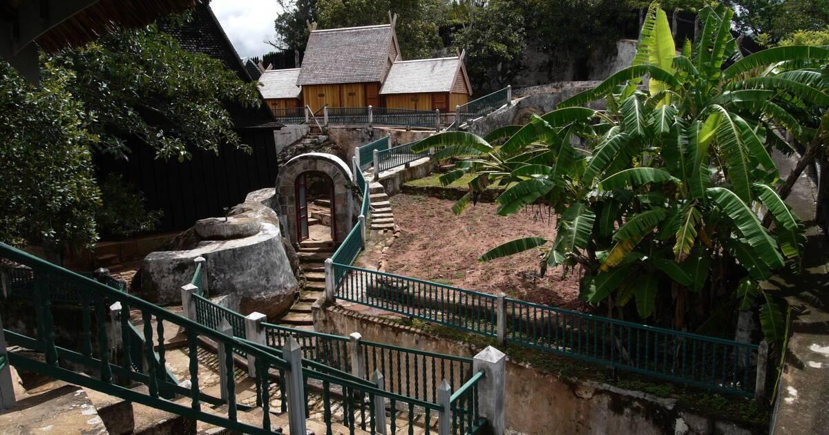 Un complesso turistico tropicale con edifici in legno, scalinate in pietra, specchi d’acqua e lussureggiante vegetazione