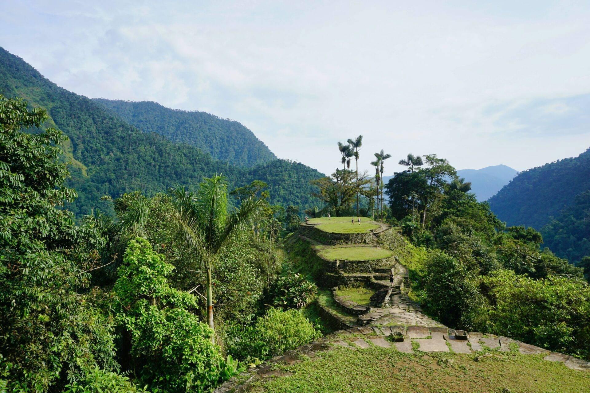 Ruinas arqueológicas escarpadas rodeadas de exuberante vegetación en un valle montañoso tropical