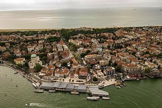 Vista aerea di una città costiera europea con architettura densa, fronte mare pittoresco e battello di trasporto marittimo