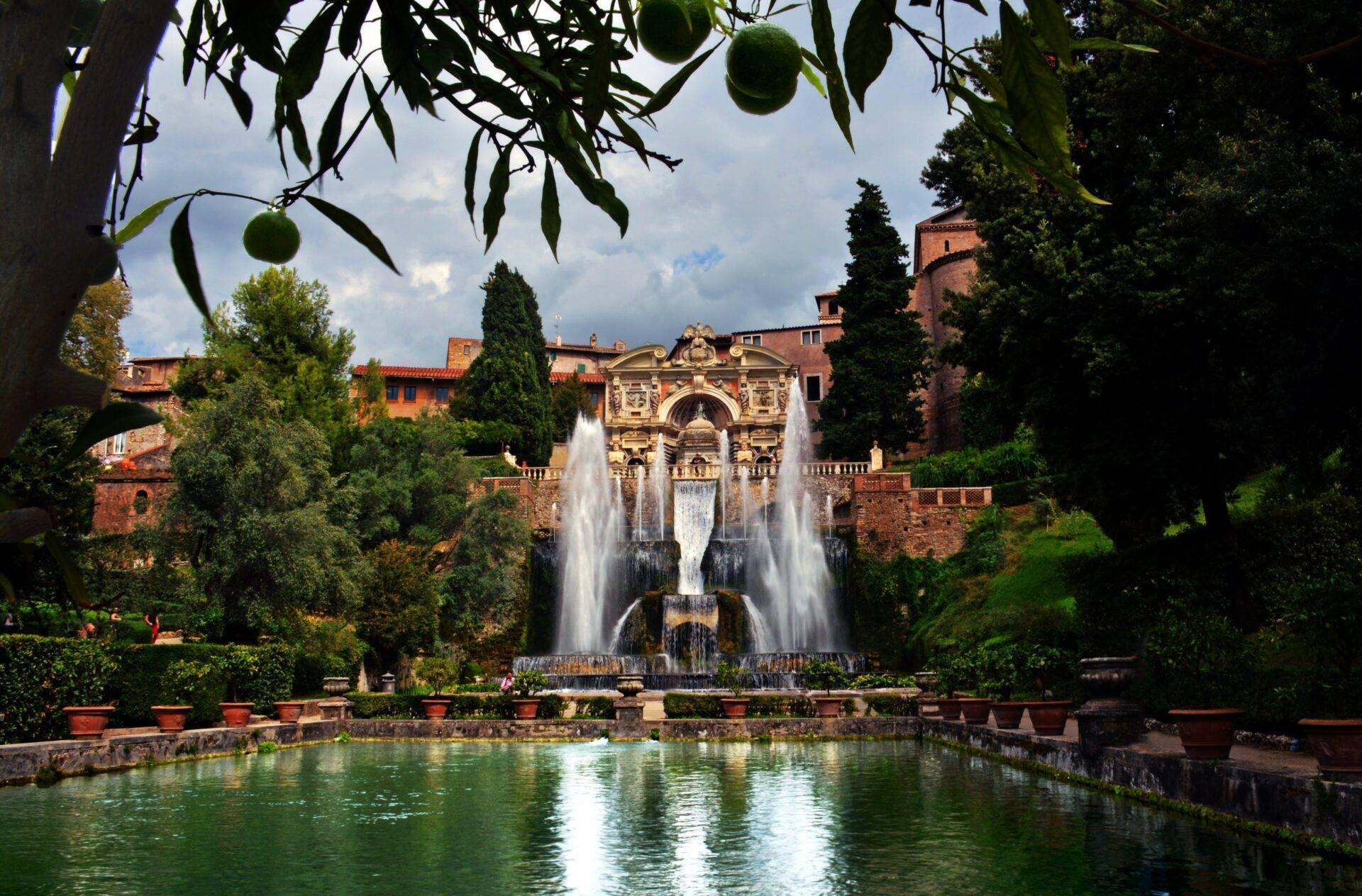 A magnificent Italian garden with a monumental fountain, a turquoise pool and a Renaissance villa in the background