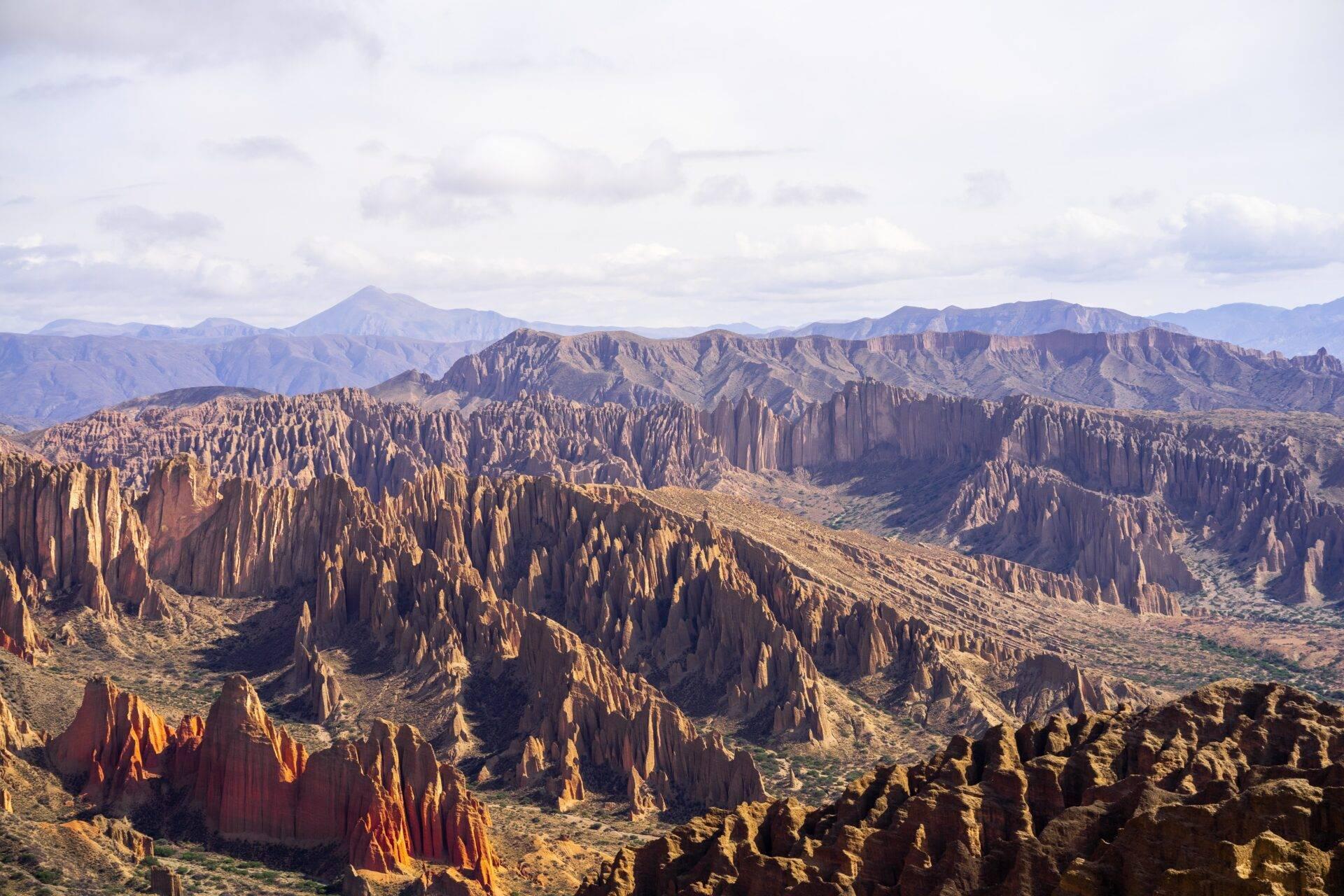 Formazioni geologiche a colonne basaltiche dominate da montagne sotto un cielo nuvoloso in Bolivia