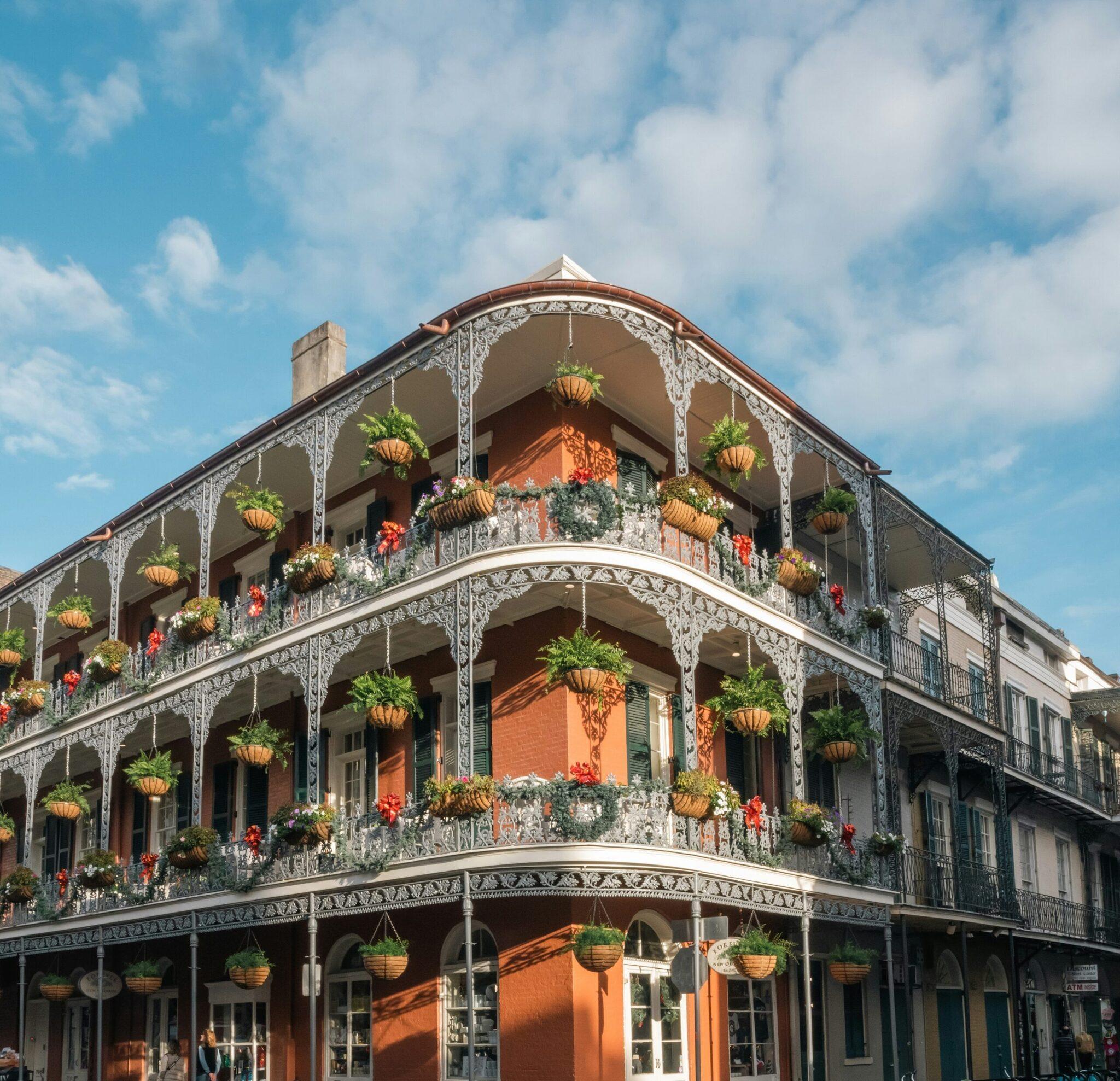 Edificio storico in mattoni rossi con balconi in ferro battuto fioriti nel Quartiere Francese di New Orleans