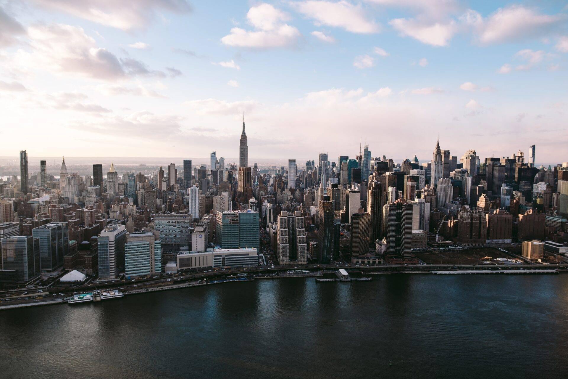 Luftaufnahme einer amerikanischen Metropole mit ikonischen Wolkenkratzern, Fluss und Waterfront unter klarem Himmel