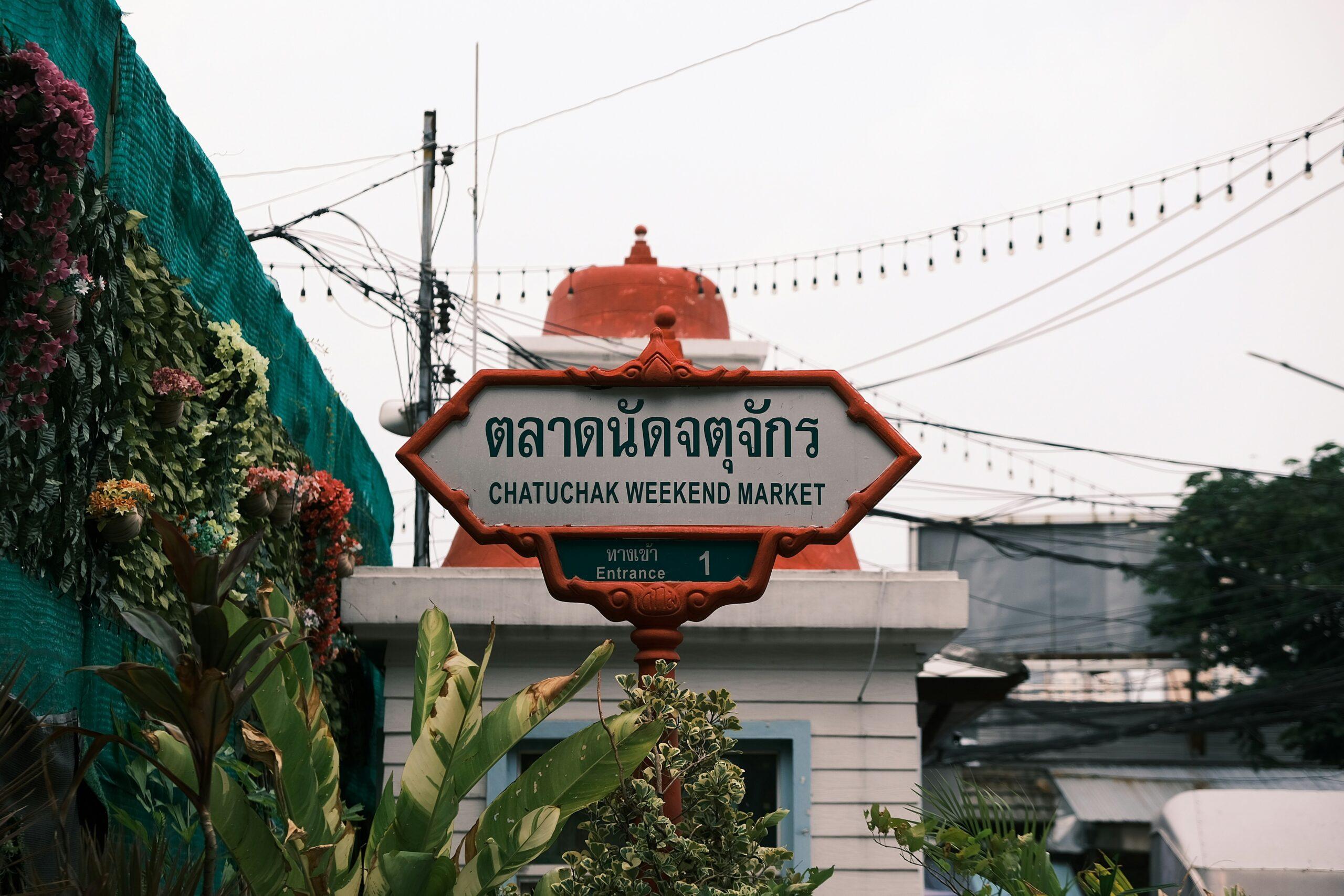 Belebte Gassen des Chatuchak-Markts in Bangkok mit Händlern und thailändischen Straßenständen