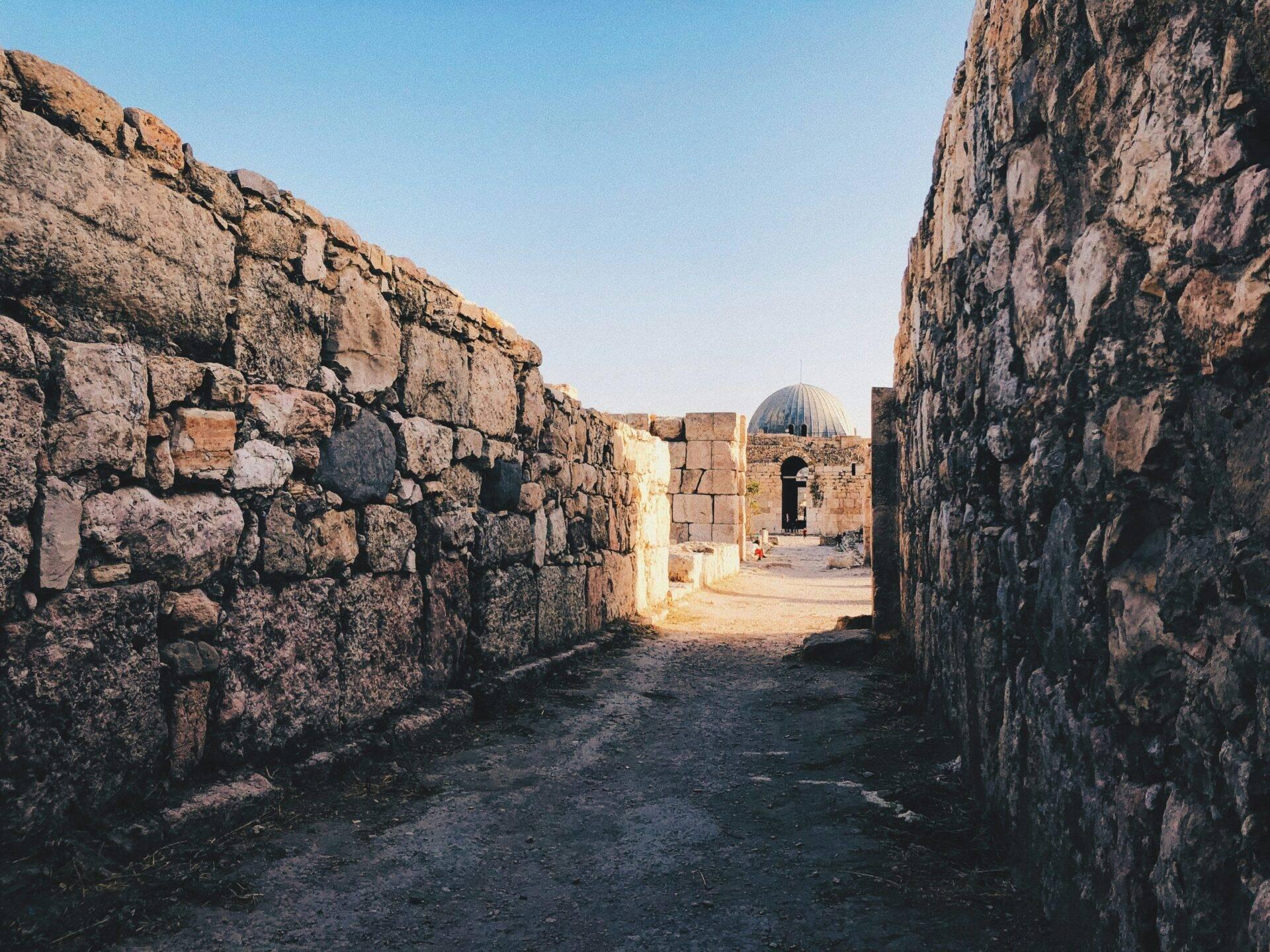 Ruinas de piedra de una fortaleza histórica con cúpula arquitectónica al centro, bajo un cielo despejado
