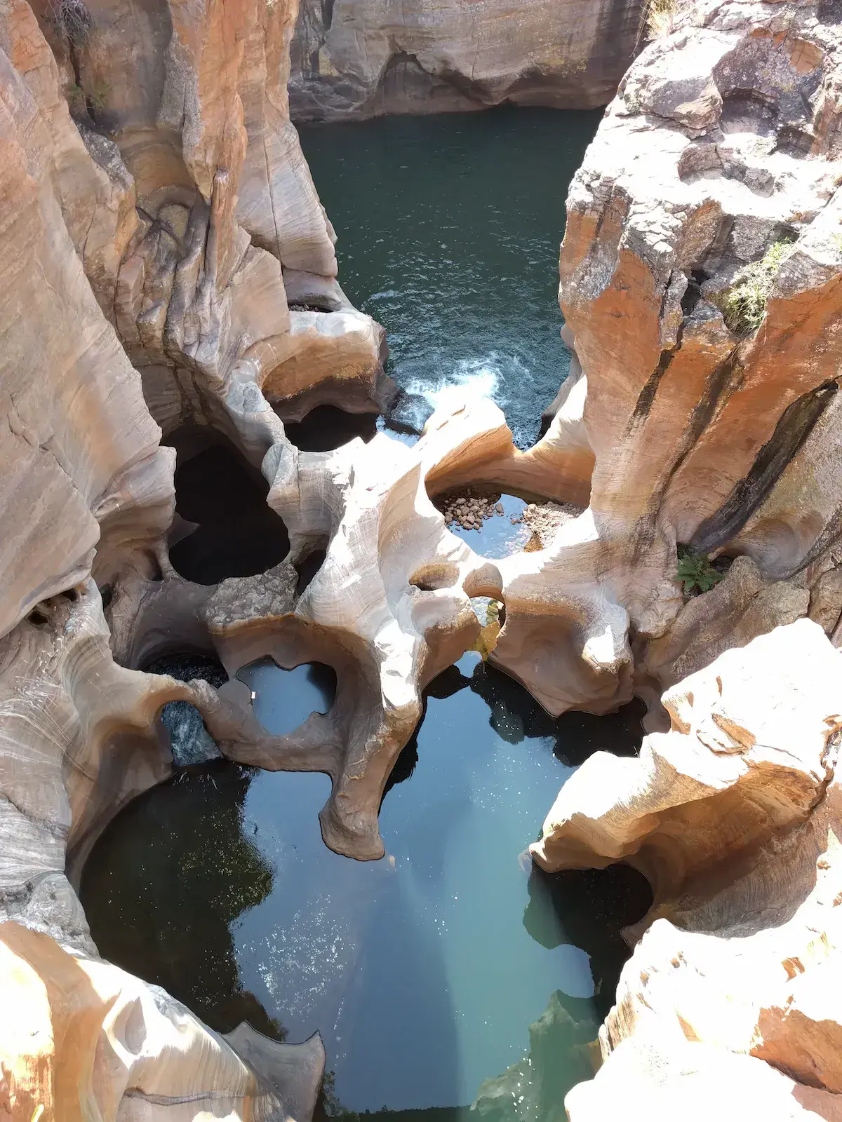 Pozas de agua turquesa naturales excavadas en las rocas ocres de un cañón africano
