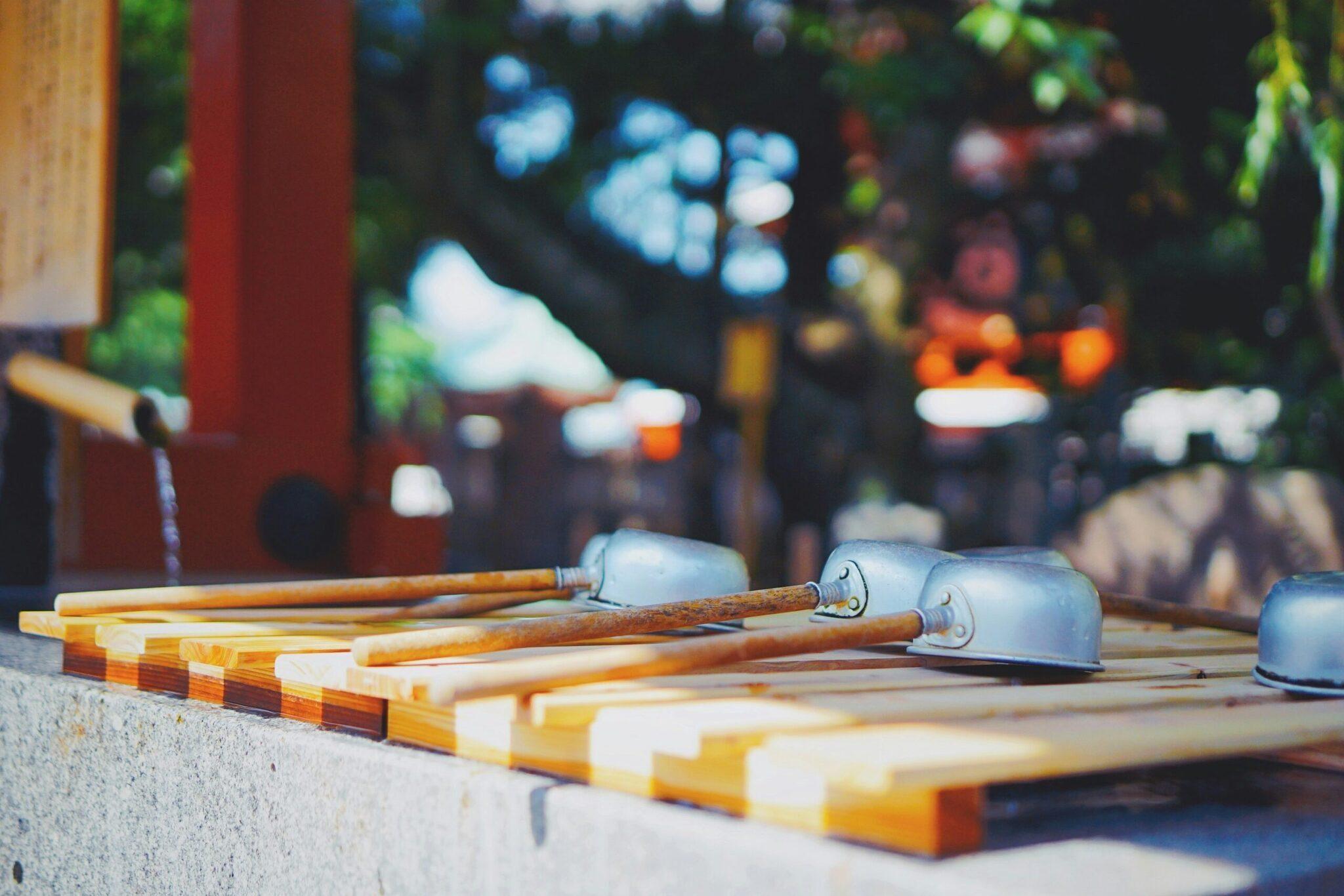 Herramientas de jardinería con mangos de madera y cabezales metálicos apoyadas sobre tablas pintadas, ambiente de taller o jardín