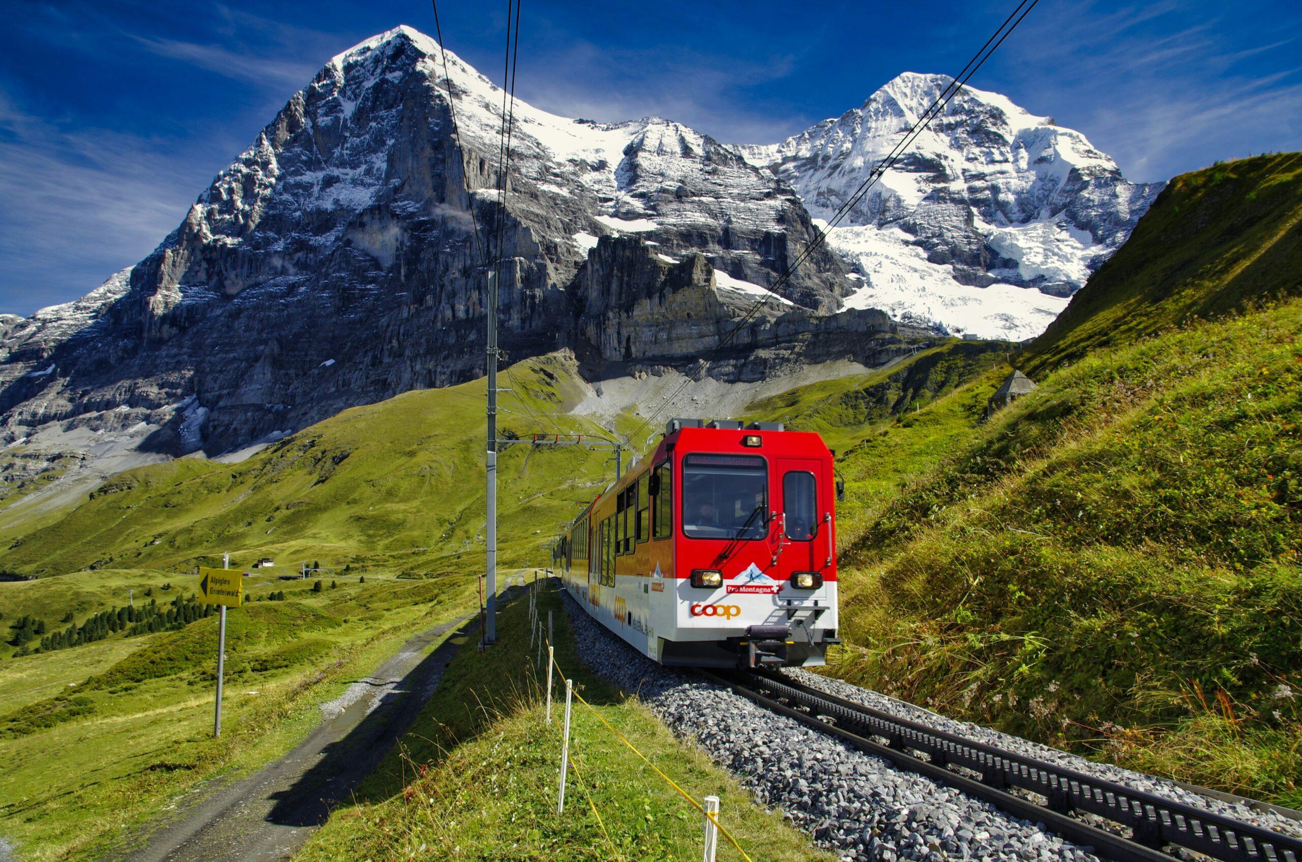 Glacier Express crossing a stone arch bridge above an Alpine gorge in Switzerland