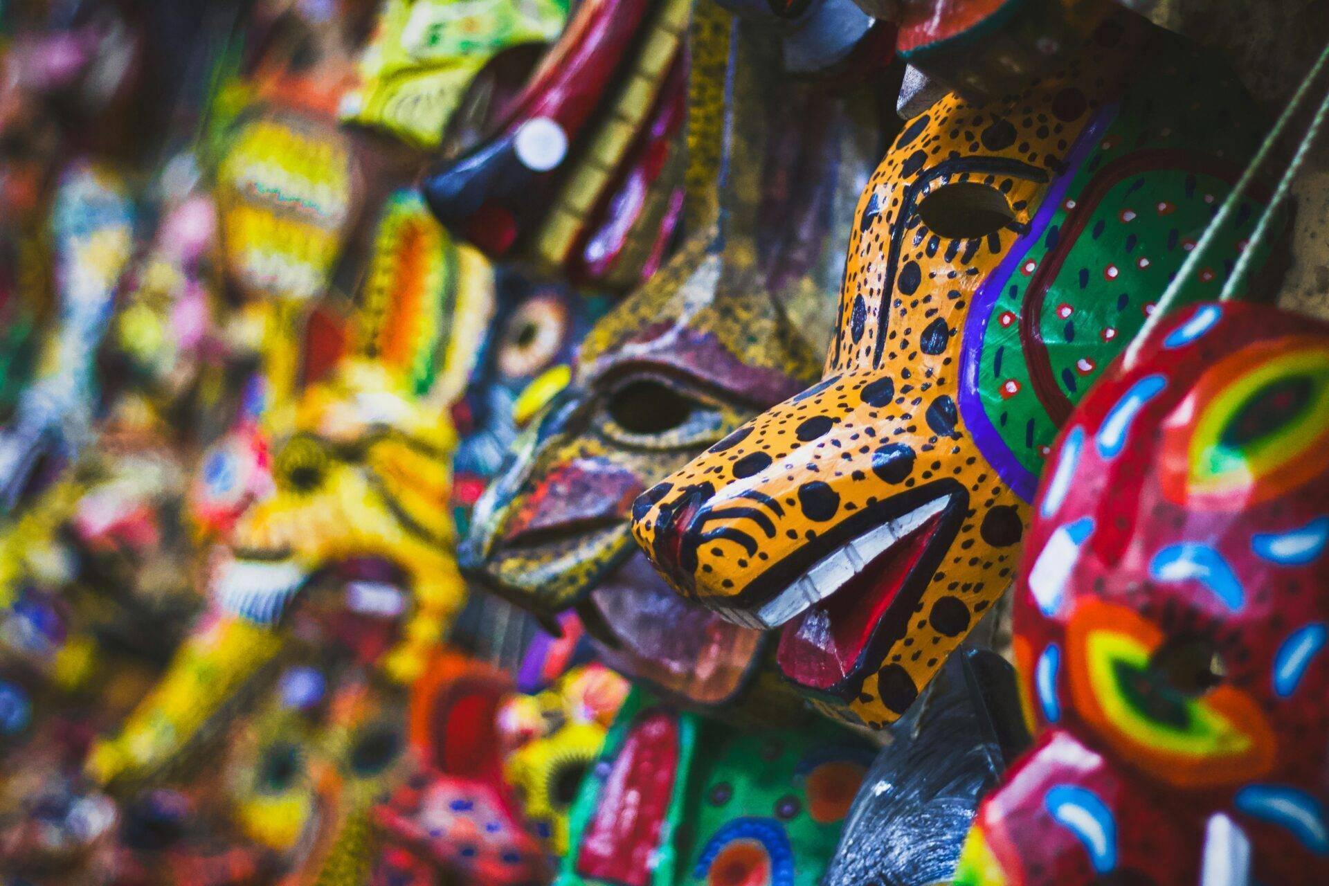 Farbenfrohe traditionelle guatemaltekische Masken mit geometrischen Mustern und leuchtenden Farben, typisch für das lokale Kunsthandwerk