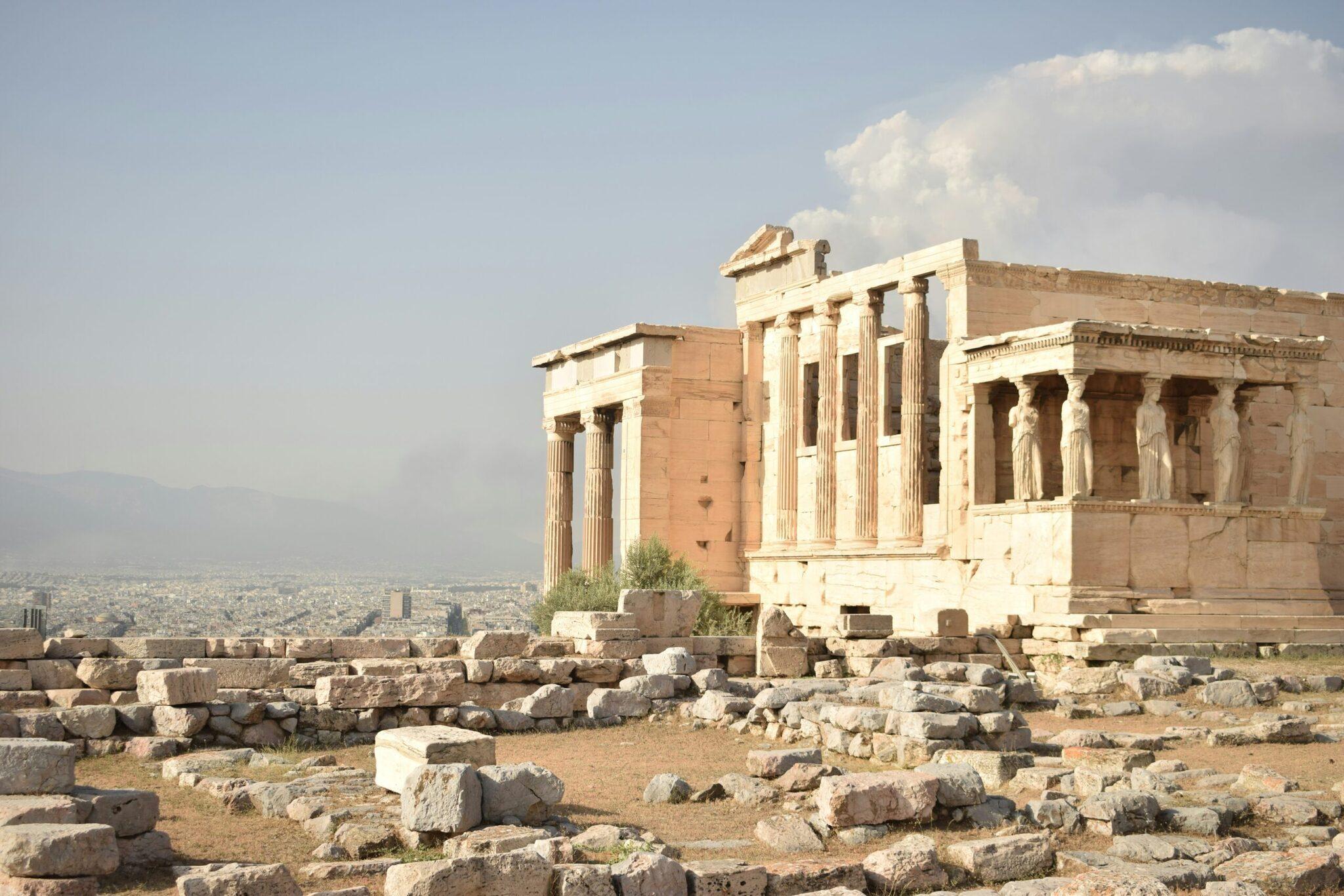 Ruinen eines antiken Tempels mit dorischen Säulen auf der Athener Akropolis mit Blick auf die Stadt