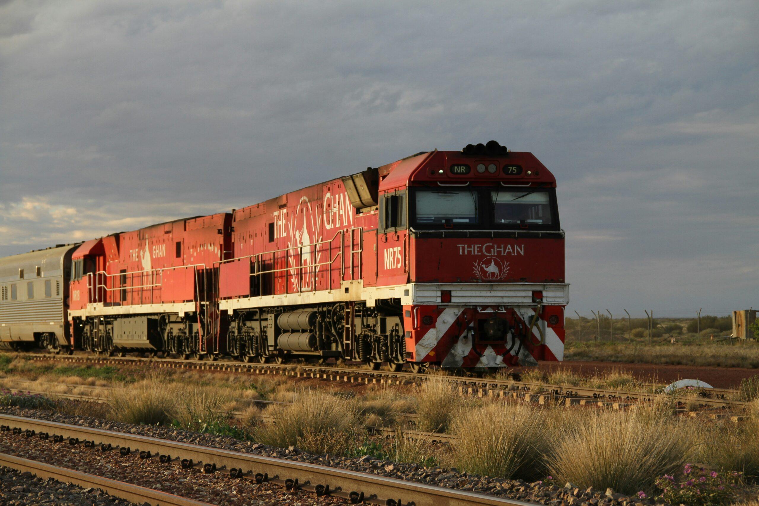 The Ghan crossing the red, arid plains of the Australian Red Centre under a vast blue sky