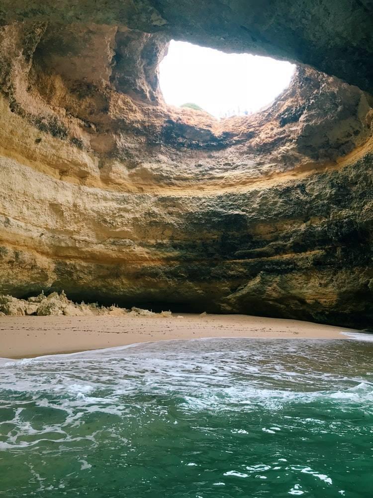 Eine beeindruckende Meeresgrotte mit natürlichem Bogengewölbe über einem Strand und dem Ozean