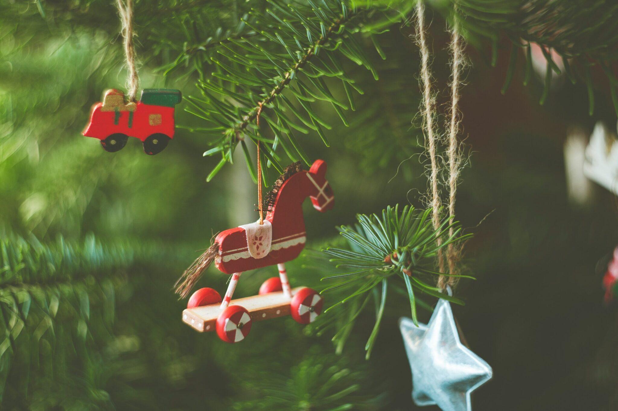 Adornos navideños rojos colgados de ramas de abeto verde, creando un ambiente festivo y acogedor