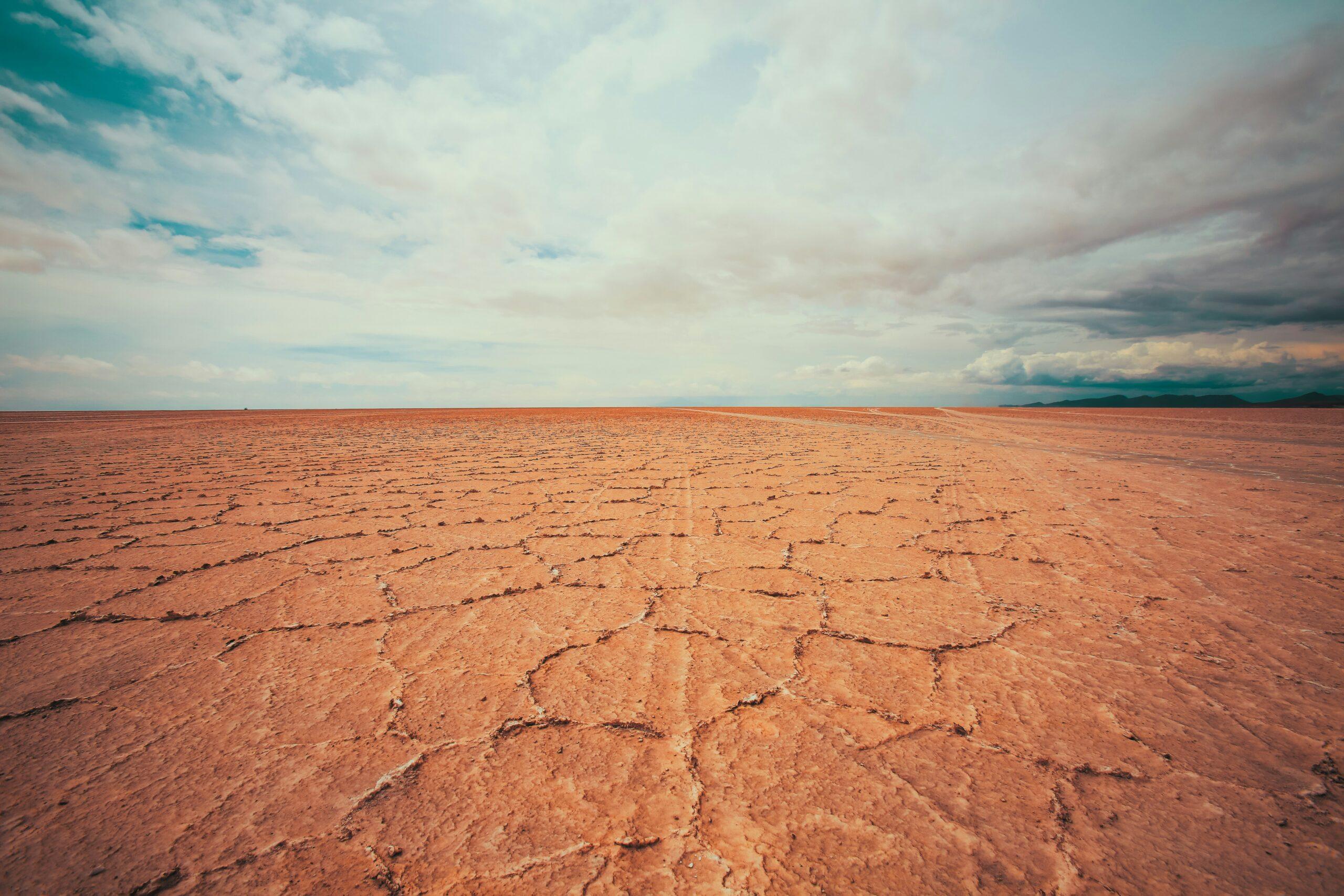 Blick auf den Vulkan Tunupa vom Ufer des Salar de Uyuni in der Dämmerung, warme Farben über der weißen Salzfläche