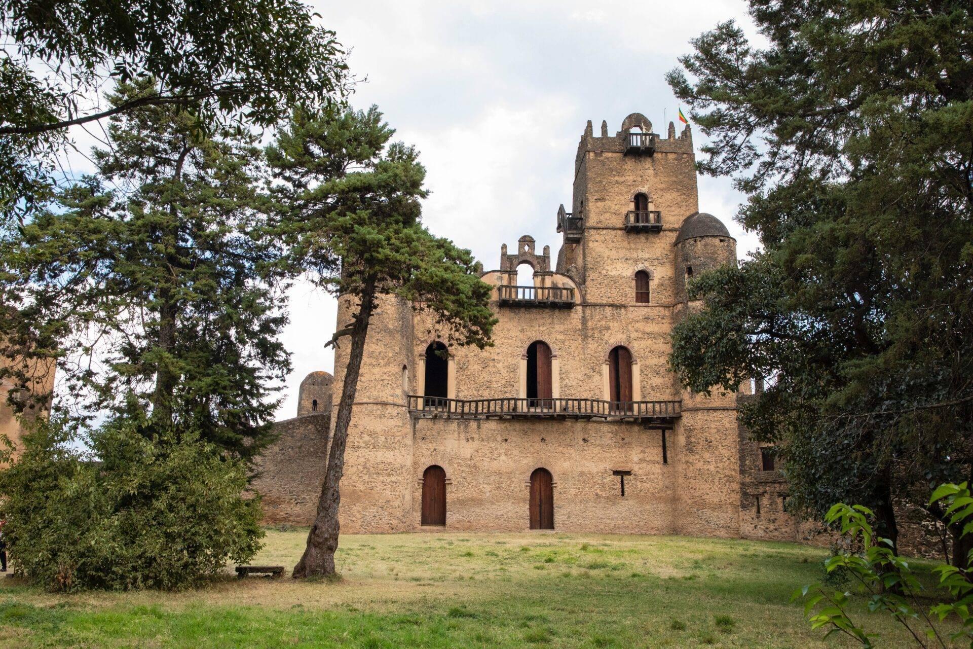 Steinerne Festung mit Zinntürmen, umgeben von üppiger Vegetation in Äthiopien