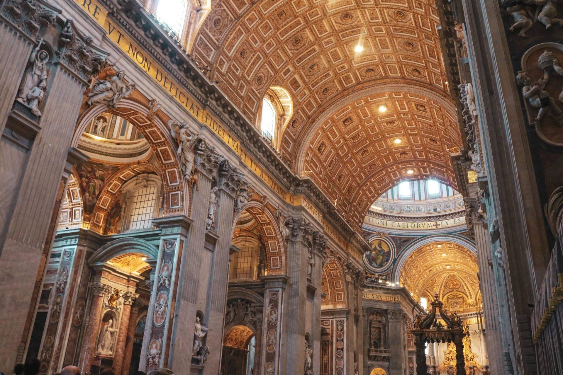 Majestic interior of a baroque basilica with gilded vaulted ceilings, ornate columns and religious sculptures