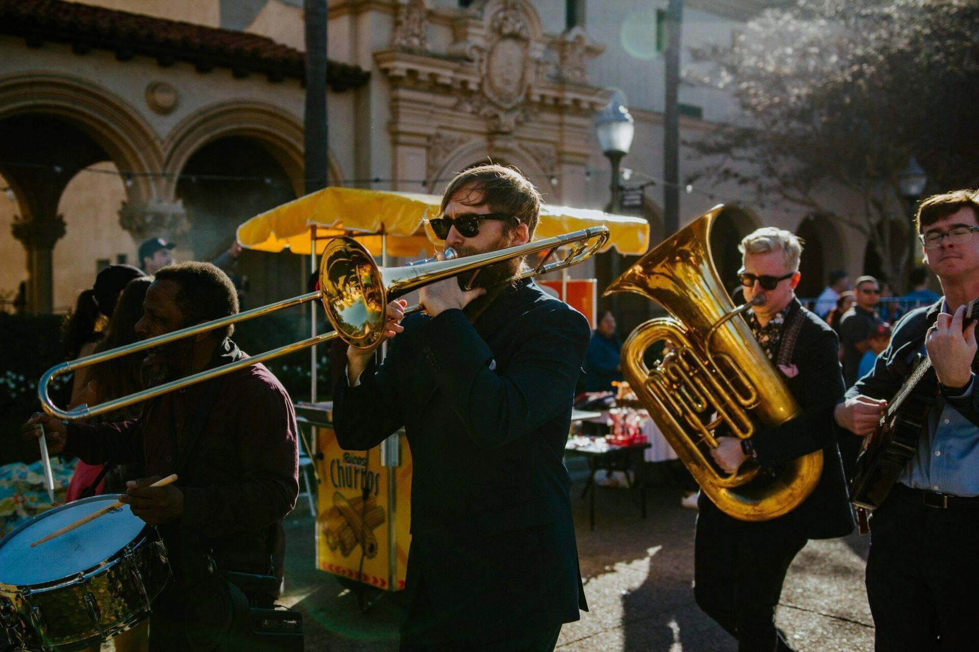 Musicisti che suonano tromba e tuba in un cortile storico durante una celebrazione festiva