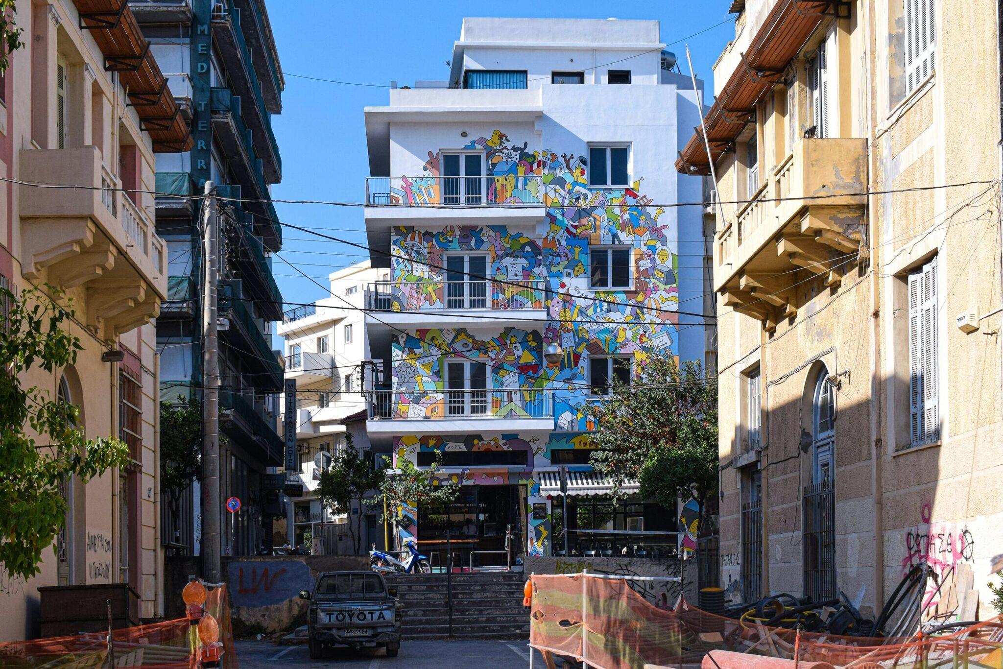 Edificio moderno con muri colorati di street art in un vicolo stretto di una città mediterranea