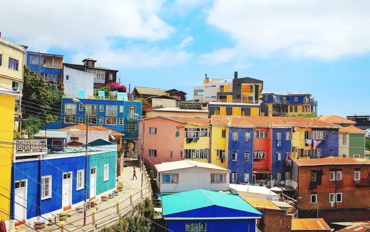 Casas de colores con fachadas amarillas, azules, rojas y rosas en las laderas de una colina costera