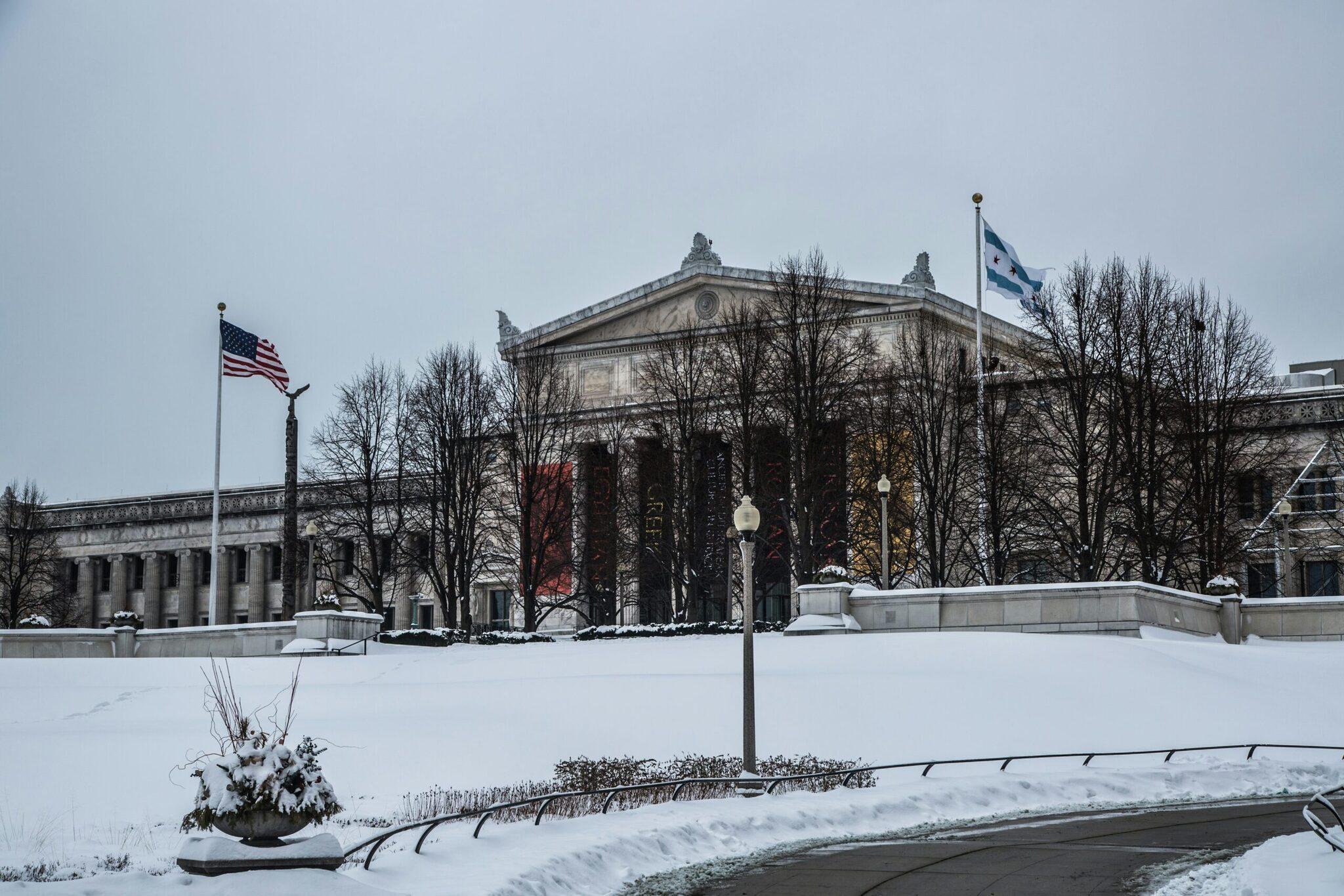 Neoklassizistisches Gebäude mit Säulen und amerikanischer Flagge im Winter, umgeben von kahlen Bäumen