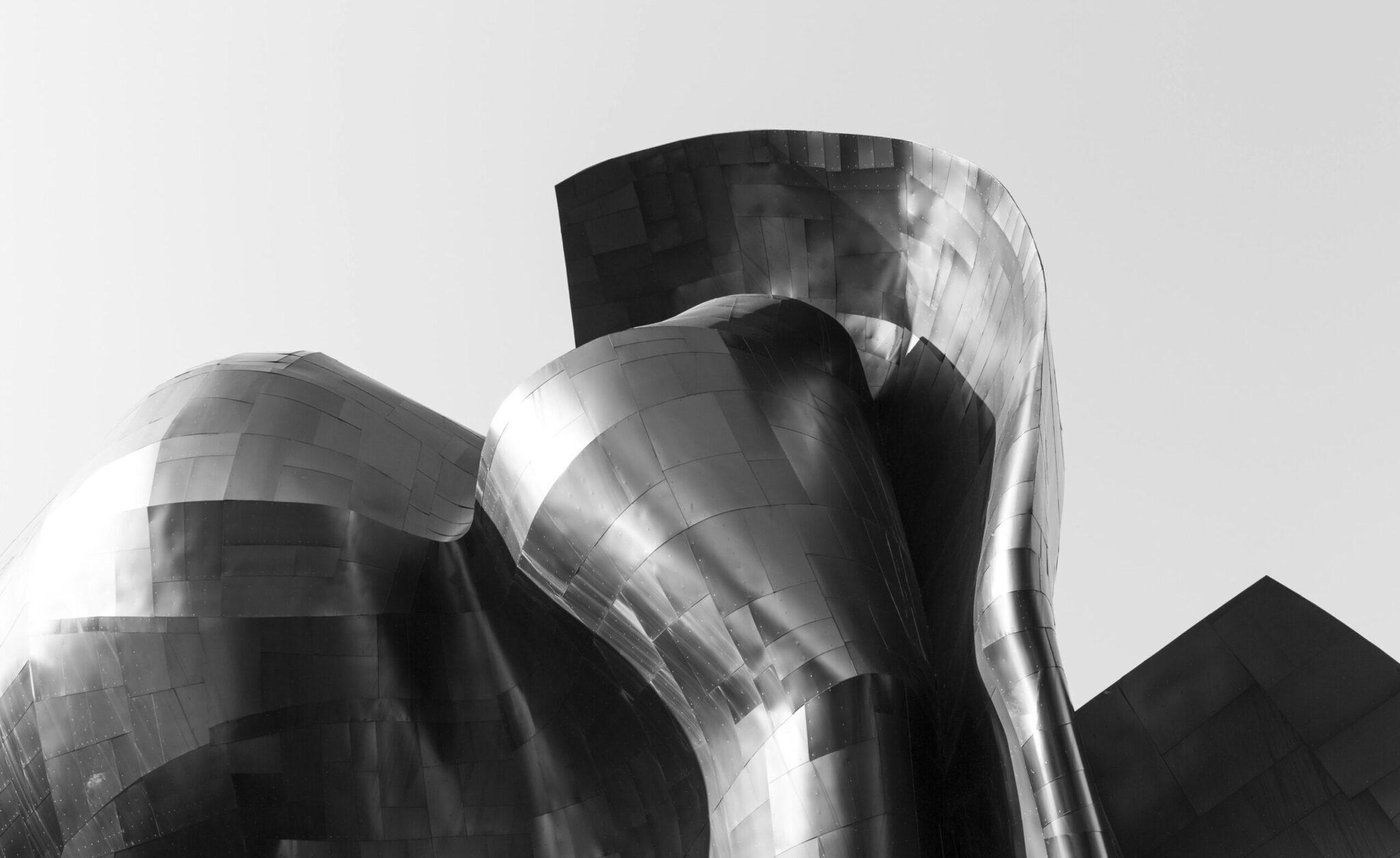 Detalle arquitectónico de metal ondulado de un edificio moderno con formas curvas y superficies reflectantes