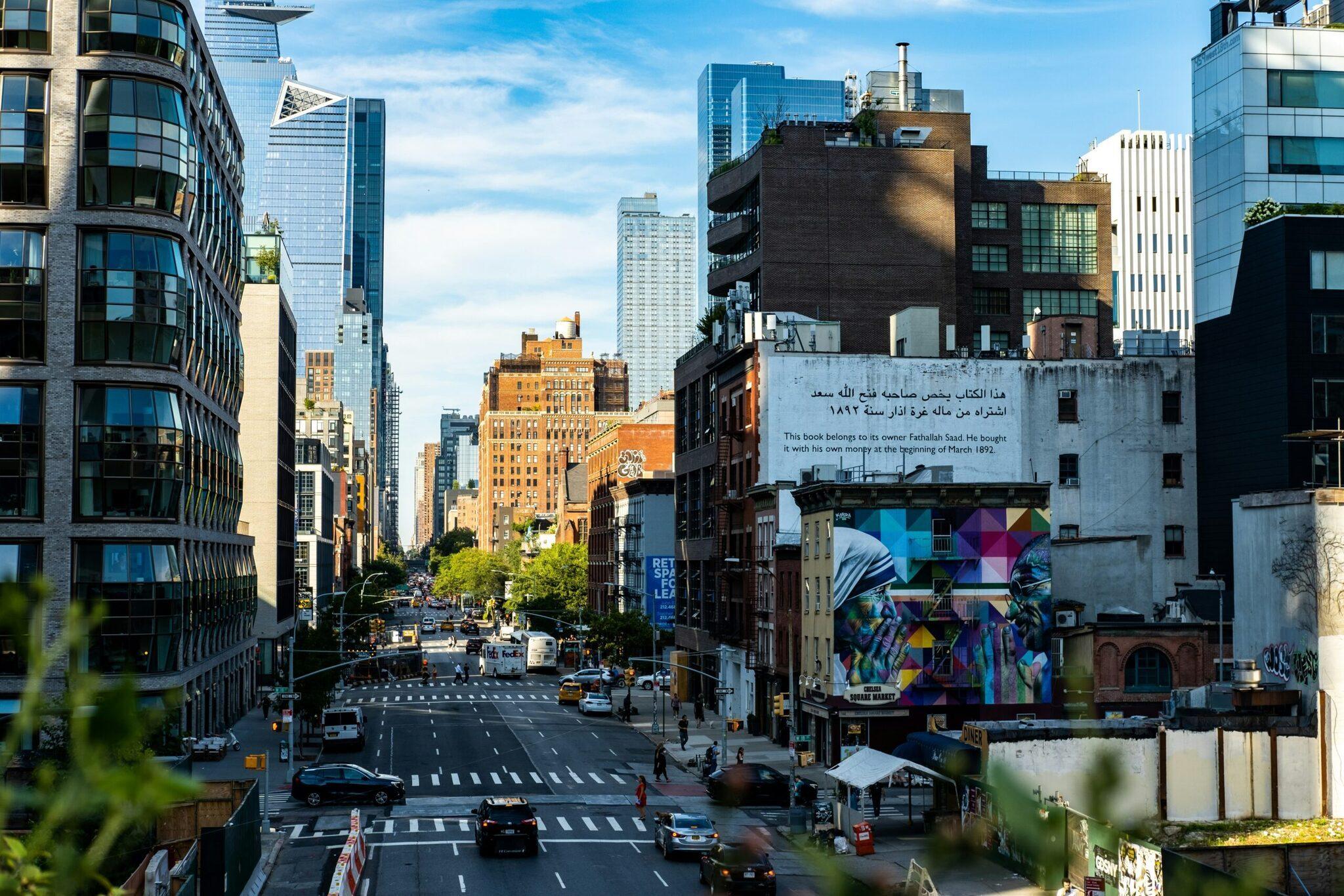 Aerial view of an urban street with historic buildings, colourful murals and traffic in an American city