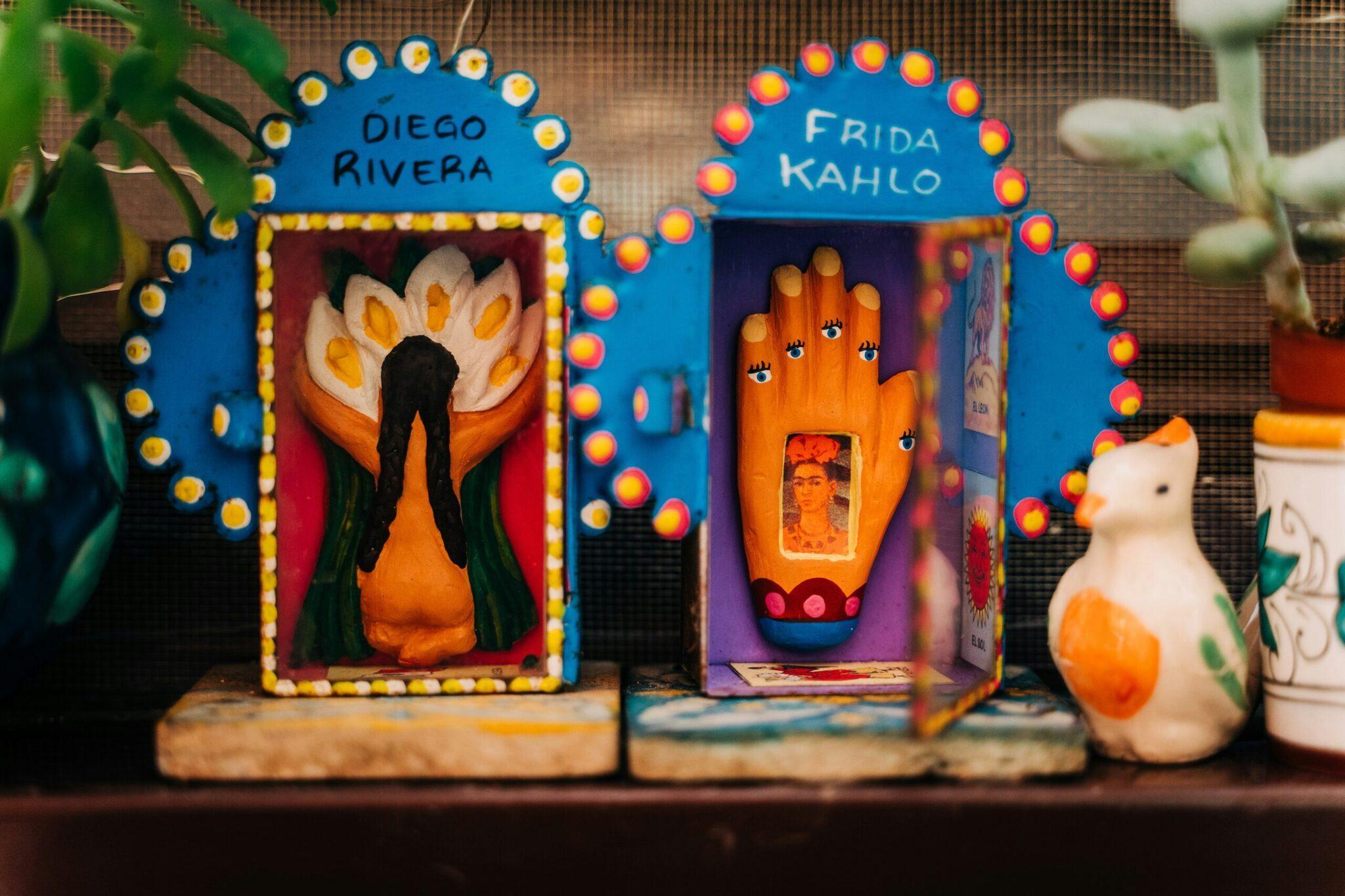 Zwei farbenprächtige mexikanische Altäre mit Lichterketten, traditionellen Motiven und Symbolen, inspiriert von Diego Rivera und Frida Kahlo