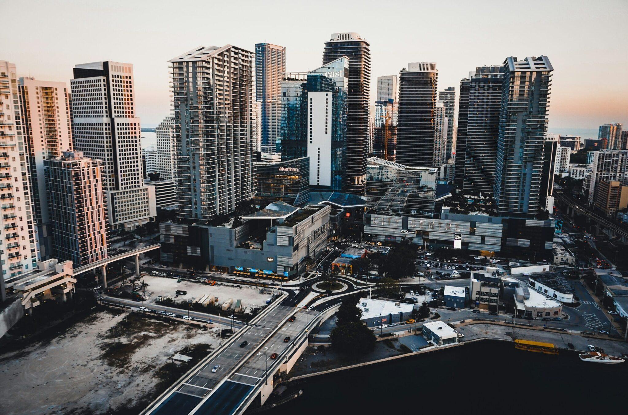 Aerial view of a coastal city with skyscrapers, elevated highways and waterfront at sunset